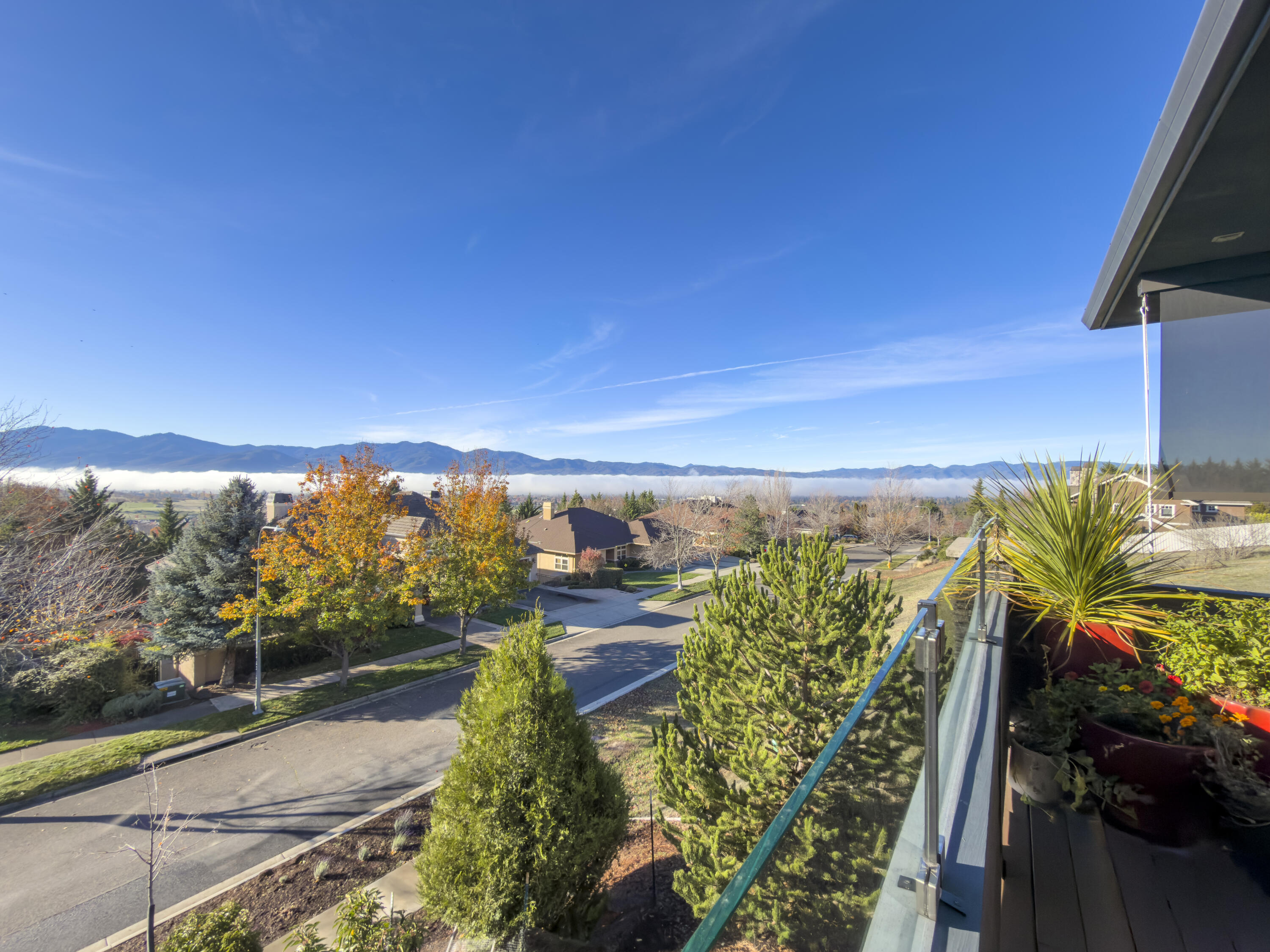 Architecturally striking and impeccably crafted, 280 Mary Bee Lane captures the essence of refined Northwest living. Designed by Ken Ogden and built by Michael Susi, this custom home is perfectly positioned to take in sweeping views of Mt. Ashland and the surrounding valley. Inside, rich Acacia hardwood floors, granite and marble surfaces, and extensive built-ins reflect a high level of finish and thoughtful detail. The main level features a spacious primary suite and subtle ADA features for long-term comfort. Outdoor living shines with a covered front deck, complete with a built-in kitchen and dining area, surrounded by beautifully selected native plantings. An oversized two-car garage, owned solar system, and optional two-family layout offer both flexibility and efficiency. A truly exceptional home in one of the area's most sought-after locations.