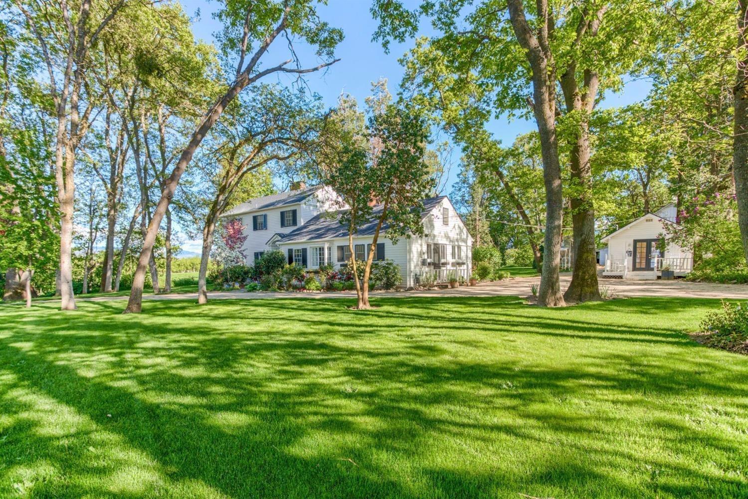 Beautiful 1921 farmhouse on 16 acre level lot with TID irrigation. This EFU zoned property resembles a park with mature trees and year round creek running through it. Main house has 4 bedrooms and 3 baths. Charming cottage house with 1 bedroom and 1 bath is a lovely additional space. Main home has three fireplaces and many period details, including built-in bookshelves. Wonderful floor plan includes formal dining room, spacious living room and a master bedroom with balcony that overlooks the backyard. Stroll across the sprawling lawn to the large vintage barn with attached shop. Additional shed is perfect for gardening supplies/plants or could serve as an artist studio. Come see this unique opportunity yourself as it won't last long.