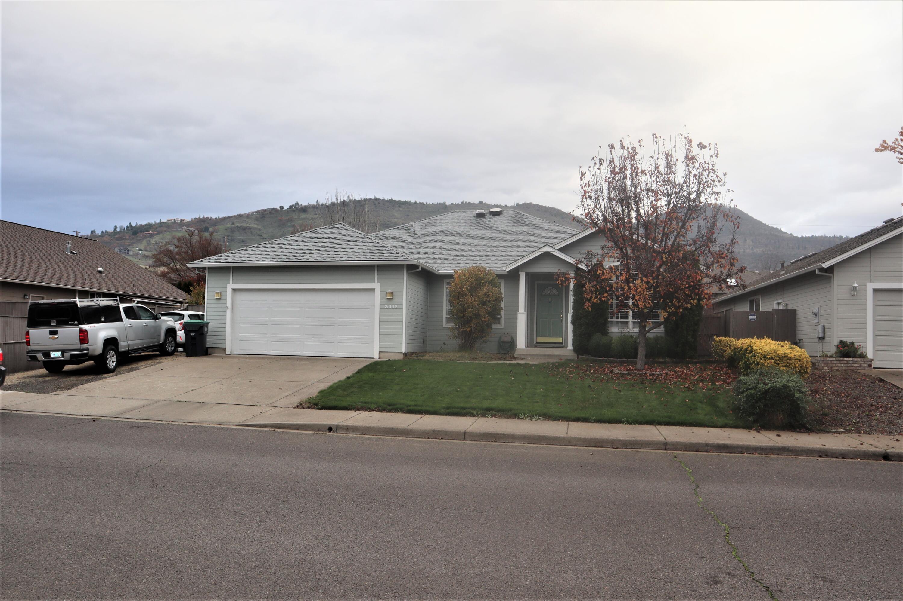 Beautiful East Medford home offers Formal Living Room & Rear Family Room with sliders leading out to the privacy-fenced yard & covered Patio - deluxe retractable Awning. Beautiful Ceramic Tile Flooring throughout Entry, Dining, Kitchen, Hallway, Baths & Laundry. This home is sporting a Newer Roof (2017) New Heating and AC Units (2018) and New In-Ground Sprinkler System both front and rear. Arched doorway leads to the Formal Living room w/Gas Fireplace. Formal Dining Room has vaulted ceiling & large windows to let in lots of light. Top of the line Plantation Shutters thru-out. Big Beautiful Kitchen with Corian Countertops, Under Cabinet lighting & Breakfast Bar with Pendant Lighting. All Appliances stay. Spacious Master Suite has coffered ceiling & Walk-In Closet. Adjoining Bath is very large & has double vanity, expansive mirrors, Vaulted Ceiling, Plant Shelf, Skylight with closable blind & oversize Shower. Attached Garage comes with lots of storage shelving. Small Gated RV Parking.
