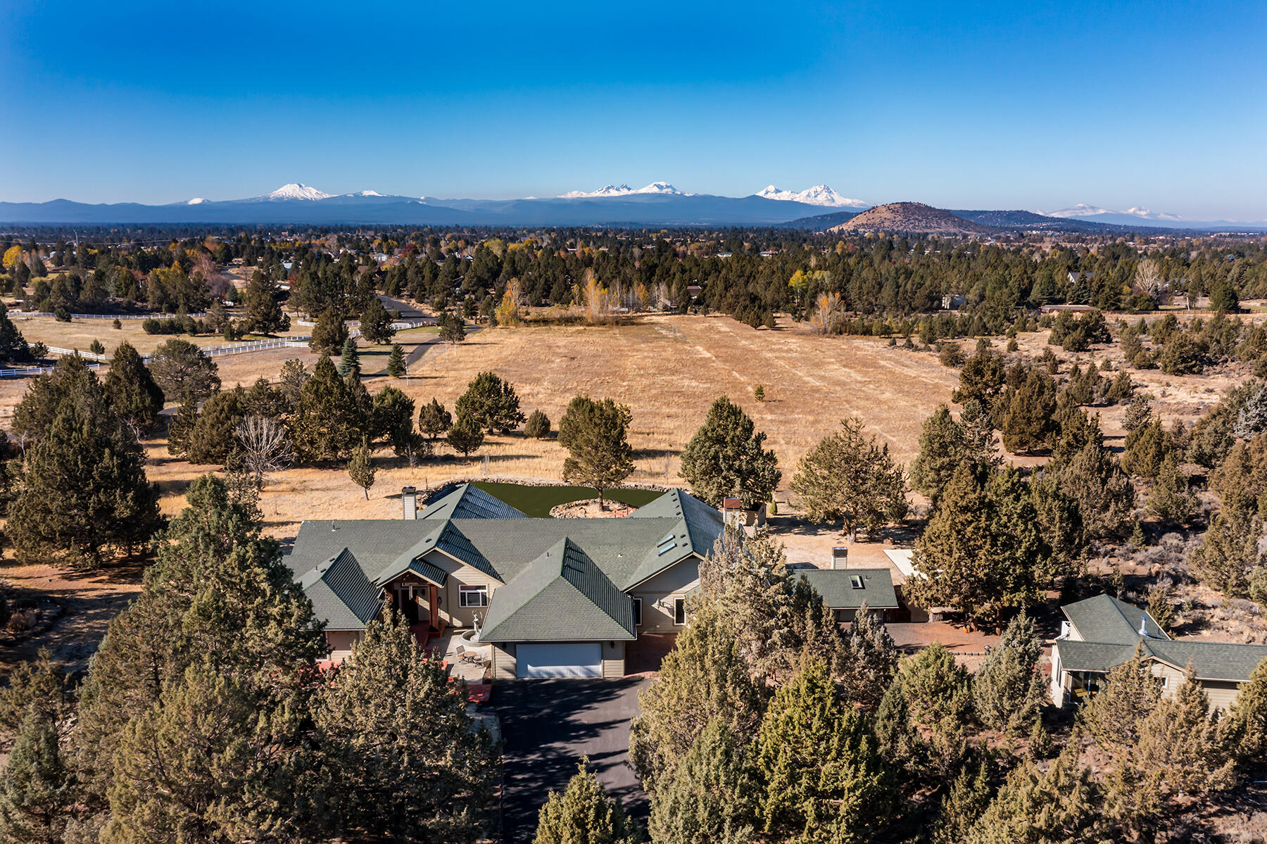 Experience country living at its best on this 30-acre Bend, Oregon estate. With 5.5 acres of irrigation, it's perfect for horses. The 3,933 sq ft home features stunning Cascade Mountain views, marble finishes, and ample natural light. The open layout, gourmet kitchen, and luxurious primary suite create a welcoming atmosphere. Outside, a large patio overlooks the picturesque landscape. A separate building has a wine cellar and comfortable lounge/bar, adding luxury and entertainment. Custom landscaping and natural beauty blend for a serene parklike setting. Whether you want a horse property, a wine lover's retreat, or a peaceful escape, this estate fulfills your dreams. Own a piece of Bend's countryside, where privacy meets elegance—a lifestyle tailored for those who appreciate the finer things.