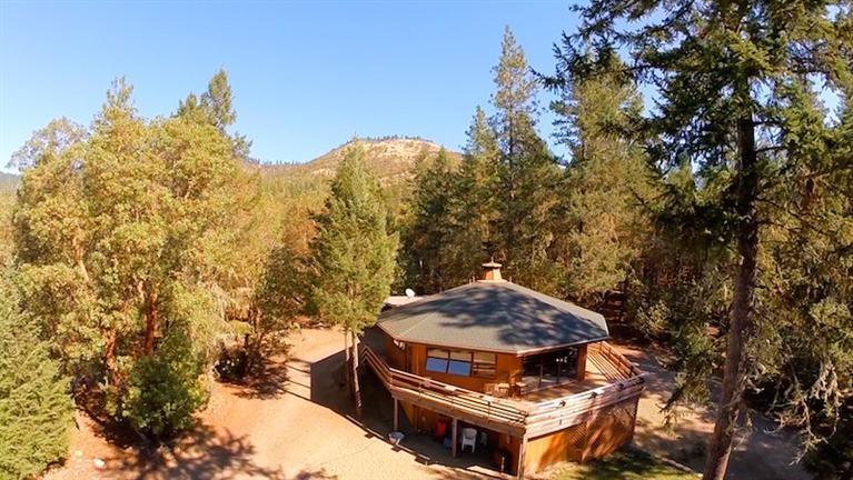Unique octagon home with room to spread out on this 7+ acre property. In the winter cozy up in the warm living room with knotty pine vaulted ceilings and a wood burning fireplace. In the summer enjoy the deck that wraps around the front of the home and the fire pit located in the front yard area perfect for making s'mores! 3rd bedroom is located downstairs, a huge space with a fireplace that can also be used as a family room or den. Also downstairs is another room that can be used as an office, shop or just for storage. Large open barn for horses or storage. Separate locked detached storage room or 2nd shop. Lots of storage inside and outside. Washer/Dryer and Fridge included. Great property for horses.