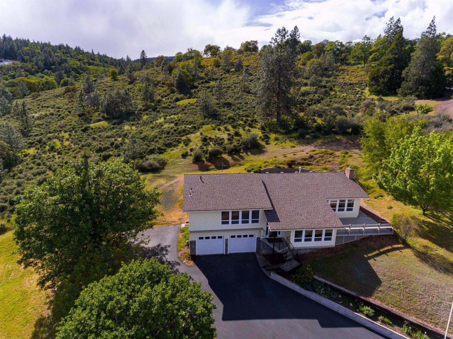 Welcome to this wonderful tri-level home and adjoining .29 acre buildable tax lot. All of this on a quiet street in a lovely neighborhood within minutes to restaurants and shopping in downtown Jacksonville. This home boasts an open kitchen with granite counter tops, gas cooktop and large island, opens up to living room with sweeping views of the the hills and valley. Views from the Master bedroom with jetted tub en suite. Bonus room on entry level, laundry on lower level. This one of a kind home and adjoining tax lot backs up to the Jacksonville Woodland hiking trails. RV parking with hook-ups and a two car garage with plenty of storage.