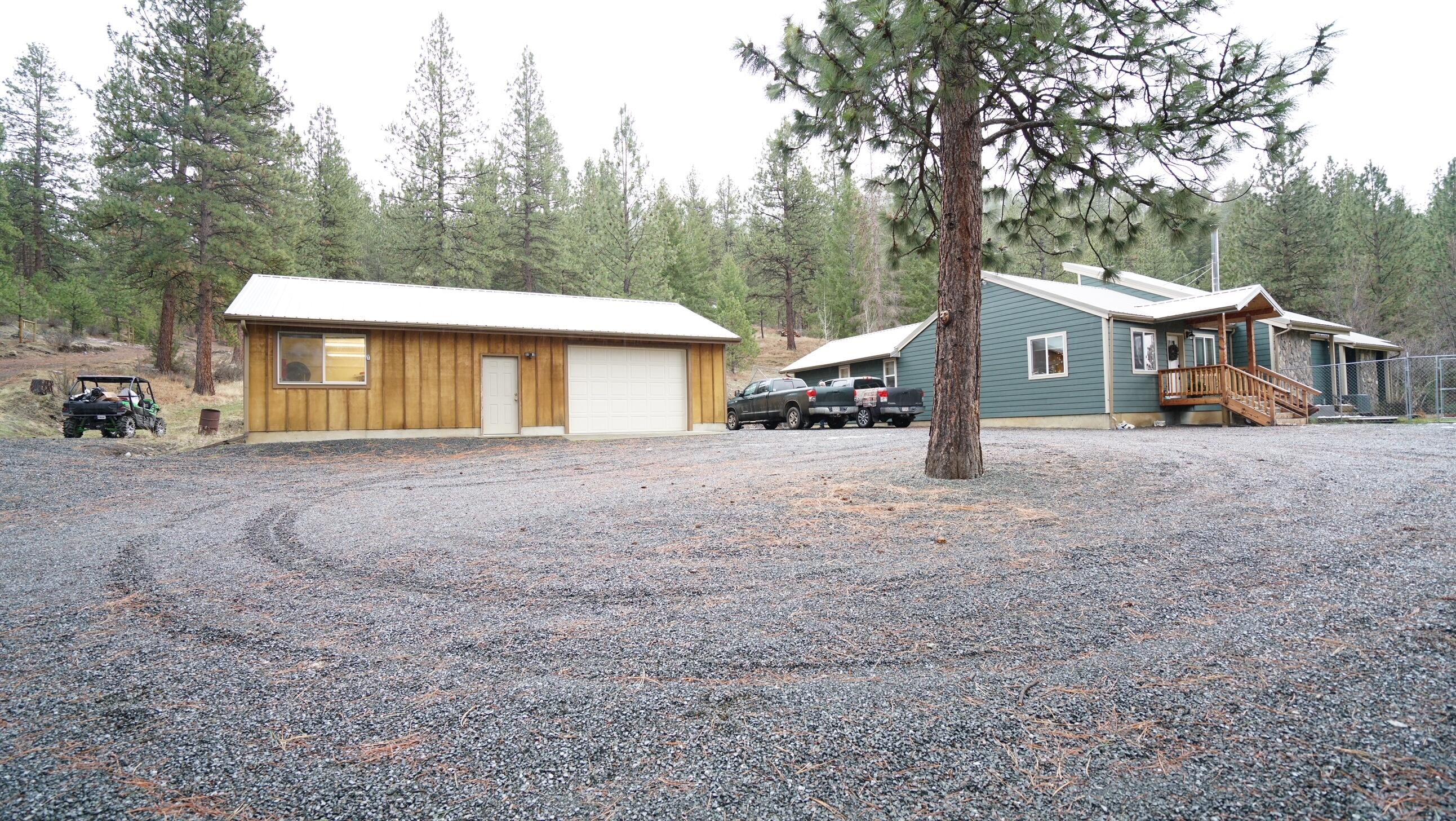 Beautiful home setting in the pine trees Bordering BLM (Public Land). This home was built in 1977 and remodeled extensively in 2017. Home offers nice open floor plan with large expansive rooms.  Two primary bedrooms with bathrooms. 4 bedrooms in total w/4th bedroom being used as a nice office. 3 bathrooms total in the home. Gorgeous granite countertops in kitchen, vaulted ceilings, large dining area and gathering area with a Blazeking woodstove. Large walk in closet for all your coats and boots/shoes. Expansive living room.  Large 26x40 finished shop with one electric garage door, 220 electricity, oil stove for heat and workshop area. Fenced yard with beautiful landscaping, retaining walls, covered patio. Perimeter of property has post set with fencing strung but not installed. New hotwater heater & septic tank installed in 2021. This is a beautiful property with access to miles and miles of public land. Very private setting at the end of the road.