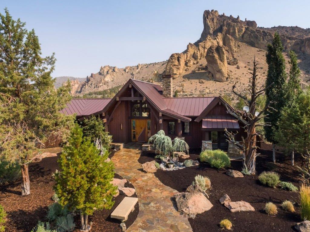 Refined and relaxed, this home was specifically designed to reflect and compliment the stunning beauty and dramatic views of the Smith Rock area. This beautiful home incorporates modern design elements throughout, open timber beams, custom iron work and floor to ceiling windows that reflect and capture the magnificent views from almost every room in the house. The great room floor plan has three bedrooms, all En suites, 4.5 baths, formal and casual dining areas, a den/office and a bonus room. The inviting and relaxing outdoor living area has a fireplace, built-in BBQ, heaters, a firepit & expansive views. An attached three car garage and 1645 sq.ft. shop/RV barn completes this one-of-a kind setting that cannot be replicated. Fully furnished including artwork. Designed and built by Norman Building & Design.