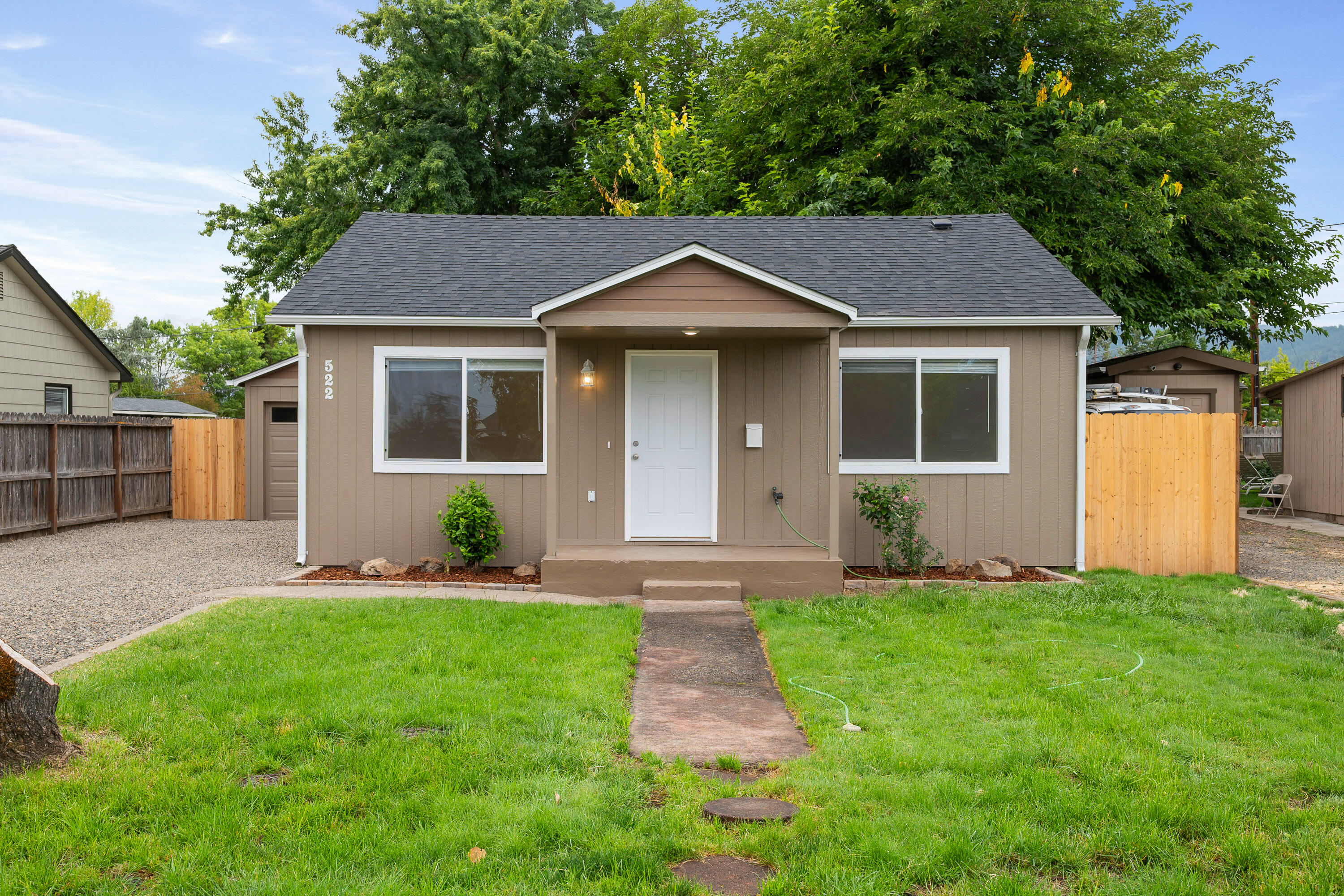 Just like new!! This sweet 2-bedroom, 1-bath home has been rebuilt with style.   Literally everything is new—electrical, plumbing, HVAC, water heater, drywall, siding, laminate flooring, light fixtures, vinyl windows, cabinets, and stunning granite countertops. The kitchen includes an eating area and blends both function and style.  Outside, you'll love the sweet front porch, spacious back patio, detached garage with laundry hookups, lots of parking, and a newly graveled driveway. The fully fenced yard offers privacy and room to enjoy. With brand-new systems and stylish finishes throughout, this home is truly turnkey—grab it while you can!