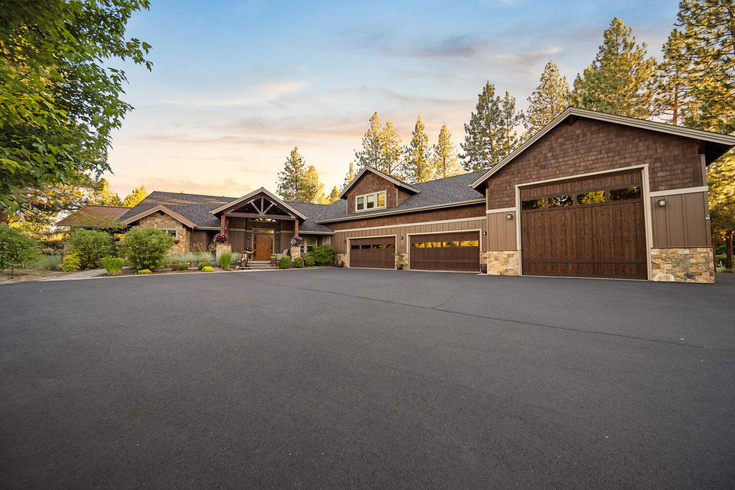 Stunning NW-style retreat in Sunset View Estates, nestled on a private 1.31-acre lot backing to common space on Lost Tracks Golf Course. This custom 3,663 sq ft home offers main-level living with open floor plan, gourmet kitchen featuring granite counters, island, dry bar with ice maker & dining area that flows into a spacious living room with stone gas fireplace.  The primary suite is a true sanctuary with beam accents, its own fireplace, heated tile floors, large walk-in shower, & direct access to a covered hot tub area. The home features three heat zones, a sound system & porch lighting with WiFi capability. A main-level 2nd primary suite & two additional bedrooms upstairs offer flexible space.  Outside is a dream—covered patio with fireplace, built-in BBQ kitchen, waterfall, fenced garden, & lush landscaping surrounded by pine trees & rock outcropping for an incredibly private setting right on the golf course. The attached 4-car garage & RV bay includes a half bath.