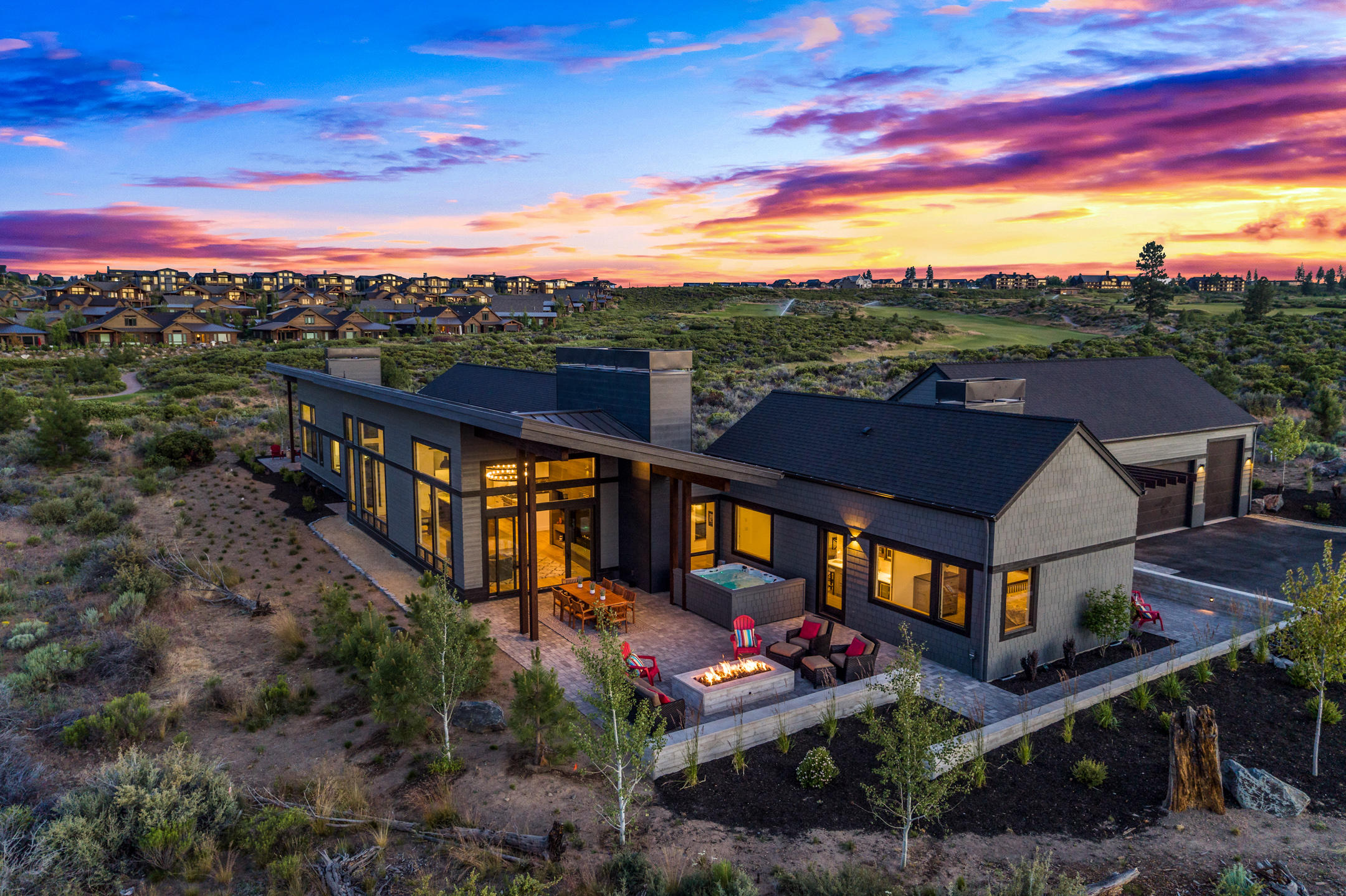 Stunning Mountain Modern single level home at end of one of Tetherow's most desired streets on famed 18th tee.  With nearly 4200 sf this home boasts high ceilings & huge windows for tons of natural light. The thoughtful design has 2 private & tranquil master suites-one with exterior entrance & kitchenette. 3 more en-suite bedrooms add to the privacy & easy livability of the home. There is a huge 3-car garage with 1 bay having an 11' door for Sprinter van or small RV. The gourmet, professional grade kitchen, 6' linear interior fireplace set in a gorgeous floor to ceiling cedar wall, 8' linear outdoor fire-pit, large patio, hot tub & appealing board form concrete walls make this home an entertainers dream. Additionally, there is a cozy home office/den with views and fireplace. The attention to detail in this home, including a powder bath with hidden secret door & Restoration Hardware vanities & lighting throughout, make this one of the most unique & beautiful homes within Tetherow.