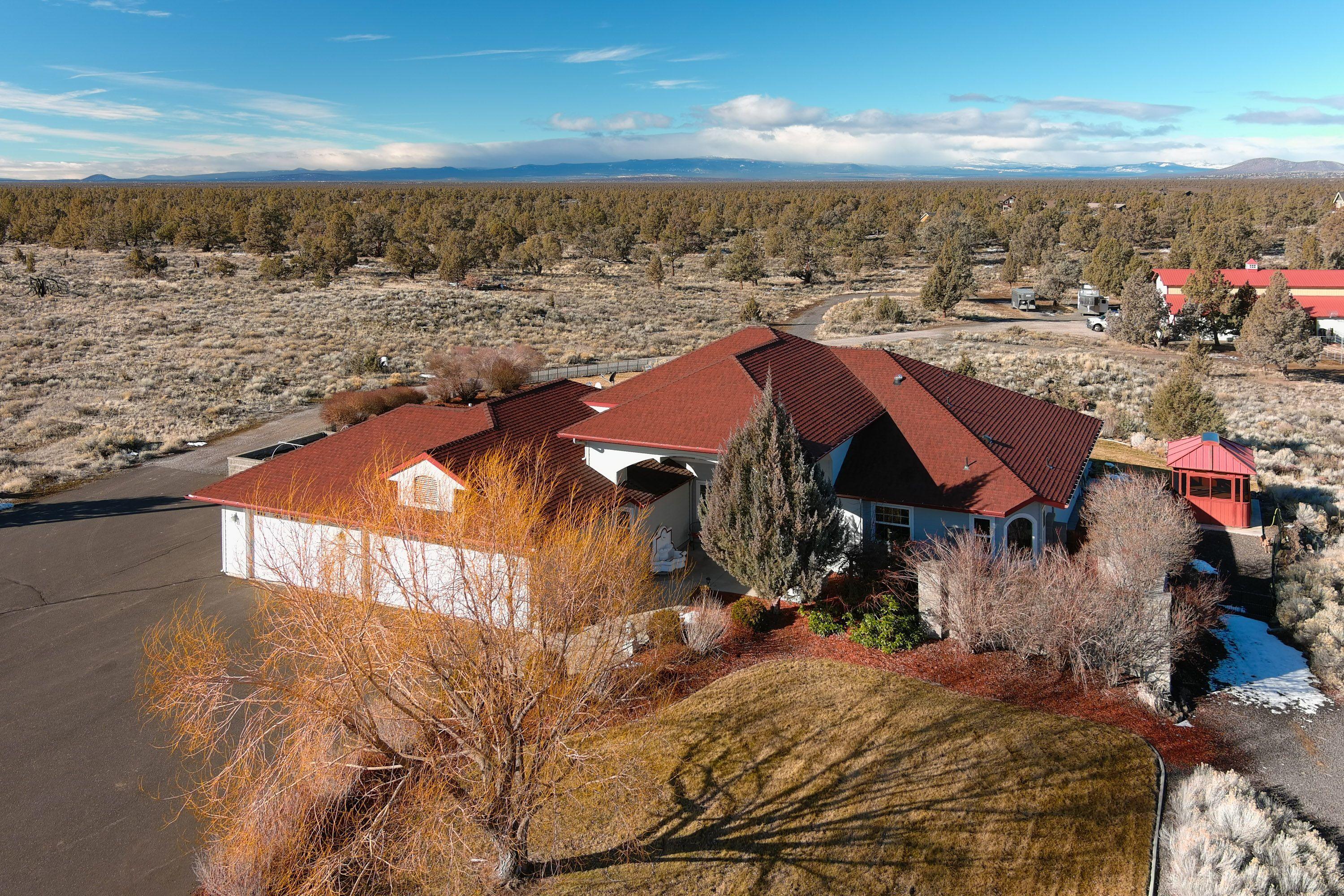 Beautiful home in gated Powell Butte community adjacent to public land. Paved driveway, single level, formal living & dining areas, a great room featuring a wall of windows to enjoy the Cascade Mountain views, propane fireplace w/river rock surround, and kitchen w/quartz counters, 5 burner propane stovetop & island w/bar seating. Master
suite includes walk-in tiled shower, jetted tub & private courtyard. Large utility room leads to finished 3 car garage. A graveled circle drive is perfect for maneuvering large trailers or RVs near the 44x60' barn/shop w/roll up RV doors. 4 stalls include adjacent runs, large heated tack room + area to store hay. The riding area is sandy for pleasure or performance riders & the property features gated access to BLM w/miles of riding trails. Fantastic private location less than 10 mins to Roberts Field Airport, Facebook, Apple Data Center, & close to Brasada Ranch Resort for dining or use of the Brasada Equestrian Center with indoor arena.