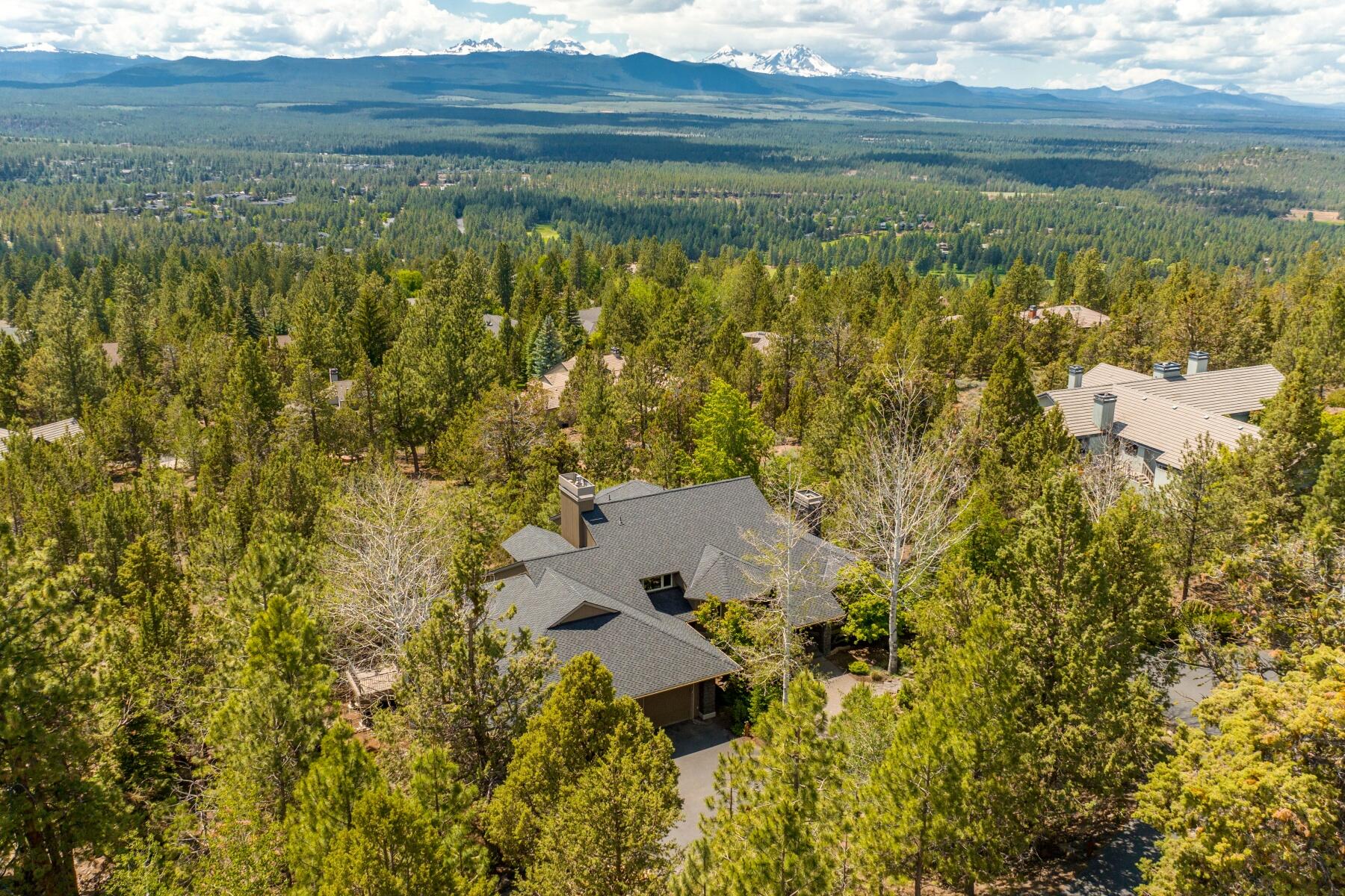 Located on an exceptional lot in Awbrey Butte, this home has Cascade Mtn views from every room! The flowing floorplan is accentuated w/stunning wood vaulted ceilings, 2 fireplaces & an abundance of windows. The well appointed kitchen offers custom cabinetry, granite countertops w/stone backsplash, a Dacor cooktop & Monogram appliances.The Primary Suite is privately located on the upper level & offers a large flex landing space, glass entry doors, large walk-in closet, dual separate vanities, curbless shower & secret bonus space. Additional features include, 2 bedroom en-suites, wine cellar & workshop w/ access to the fenced yard & storage room, laundry/craft space, office & extended 3 car garage.  The extensive paver patio can be enjoyed along with a hot tub and the outdoor living spaces w/ access to the eco- lawn with an approved fence.The exterior boasts mature landscaping & water feature. This is a very special home!