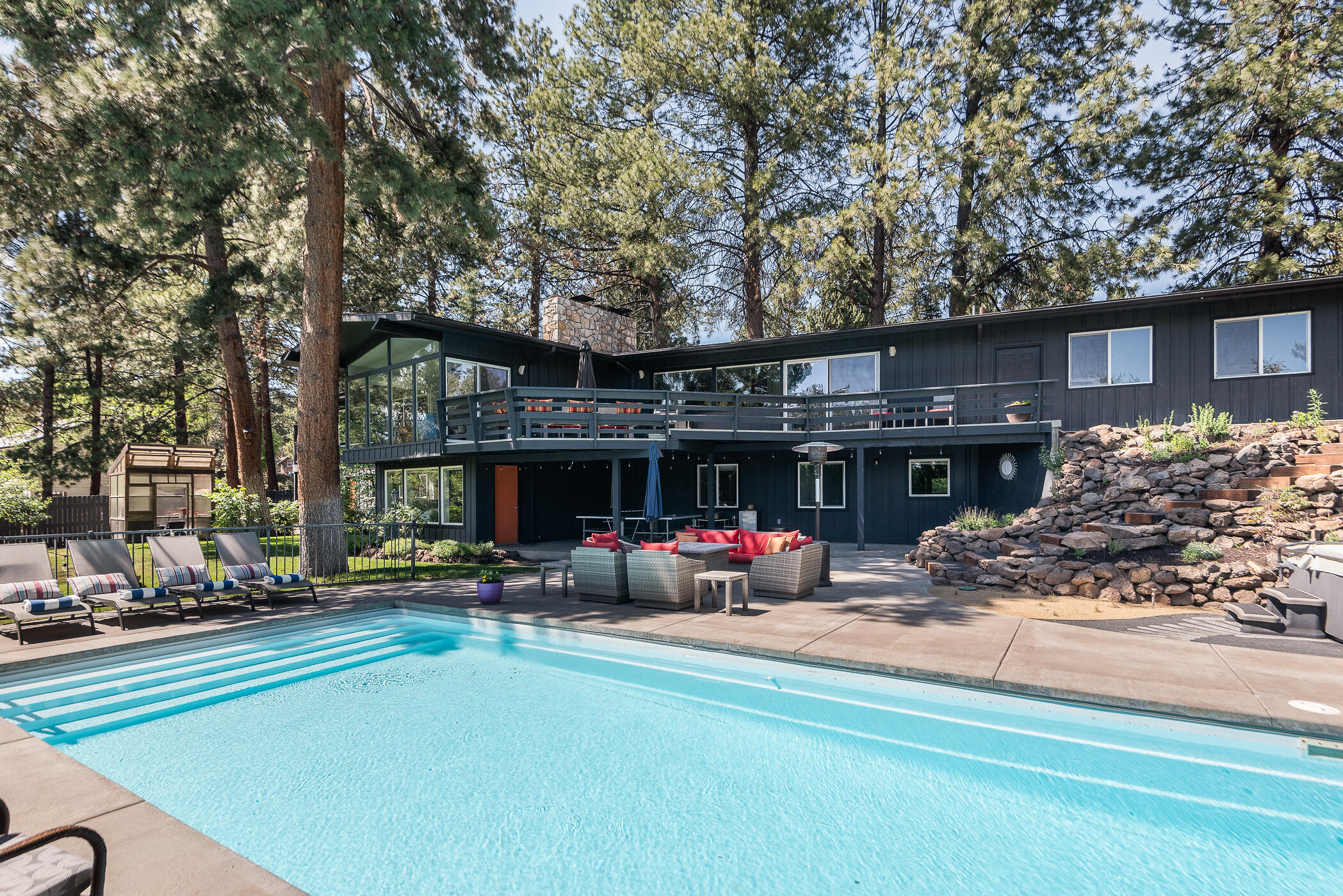 If you are a Mid Century Modern enthusiast this is what you have been waiting for! Originally built in 1961 as a personal residence by the developer of the West Hills subdivision, this stunning home could be yours!  Warm and inviting as you enter and are greeted with floor to ceiling windows overlooking an absolutely spectacular backyard. The park like yard is fully fenced with mature landscaping and a greenhouse. The saltwater pool is perfect for entertaining as are the spacious patios surrounding it. The chef's kitchen has all of the modern necessities and upgrades and blends seamlessly with the original architecture, finishes and lighting. Spacious primary with a newly remodeled bath and private deck with hot tub. Second bedroom or office and multiple main floor living areas. Venture downstairs to the daylight basement, plenty of room for guests with 3 bedrooms and a bonus room.  Hillside Park is at your door as well as all Bend amenities. This is the ultimate escape in Bend!