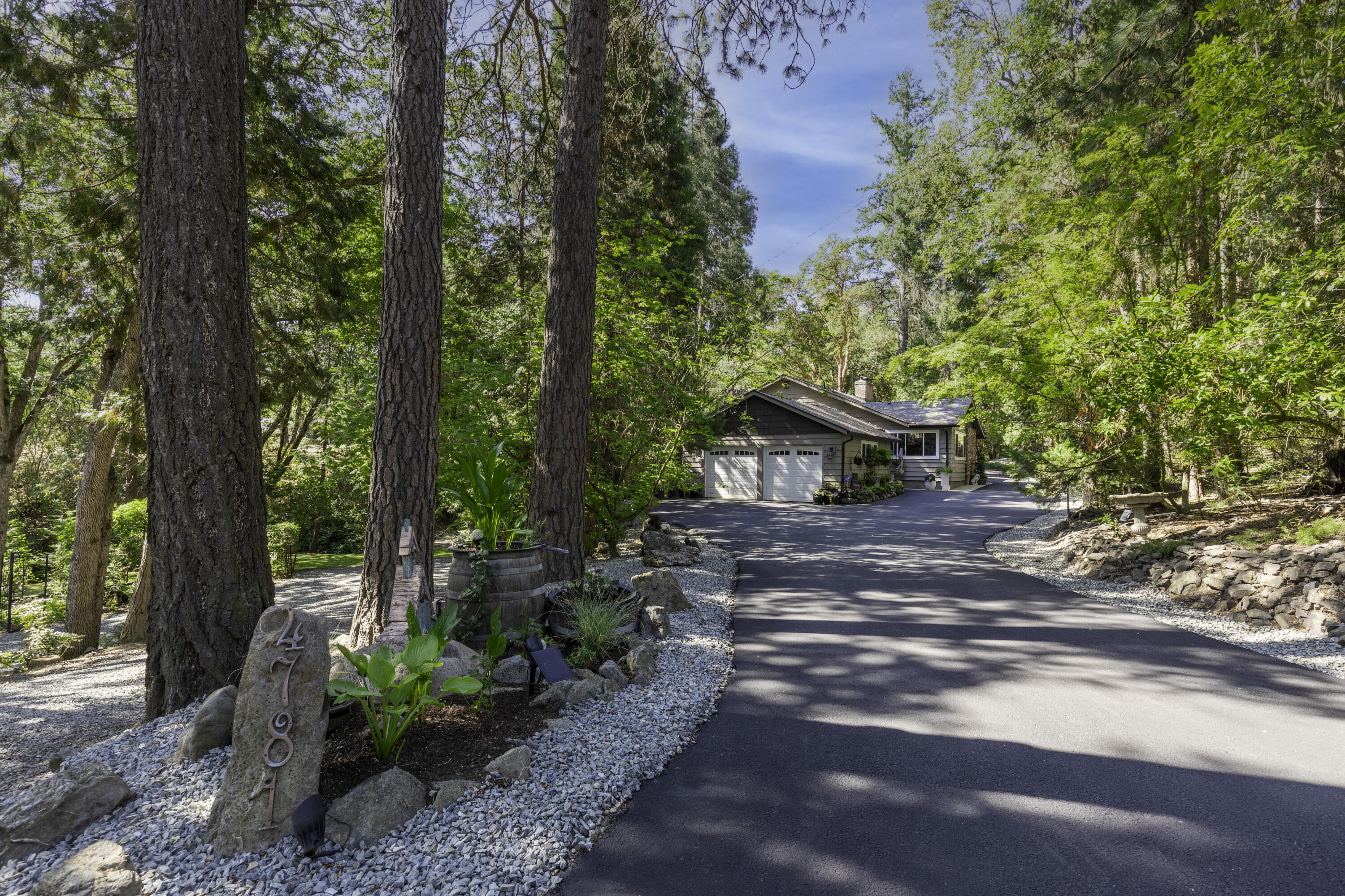 Welcome to your own private estate in Southern Oregon. This beautifully maintained 3 bedroom, 2.5 bath home sits on just over two acres of pristine, park-like setting with Coleman Creek flowing gently through. The property includes Talent Irrigation rights, perfect for maintaining the lush grounds or cultivating a garden. Inside, you'll find soaring vaulted ceilings, hardwood floors, and a spacious family room that's perfect for relaxing or entertaining.  The fully remodeled 640 square foot guest house has its own power meter and septic system, offering flexibility for guests, extended family, or potential rental income. All structures have 50 year presidential roofs that were installed in 2018, providing lasting quality and peace of mind. Private, peaceful, and beautifully kept, this is a rare find in an exceptional location.