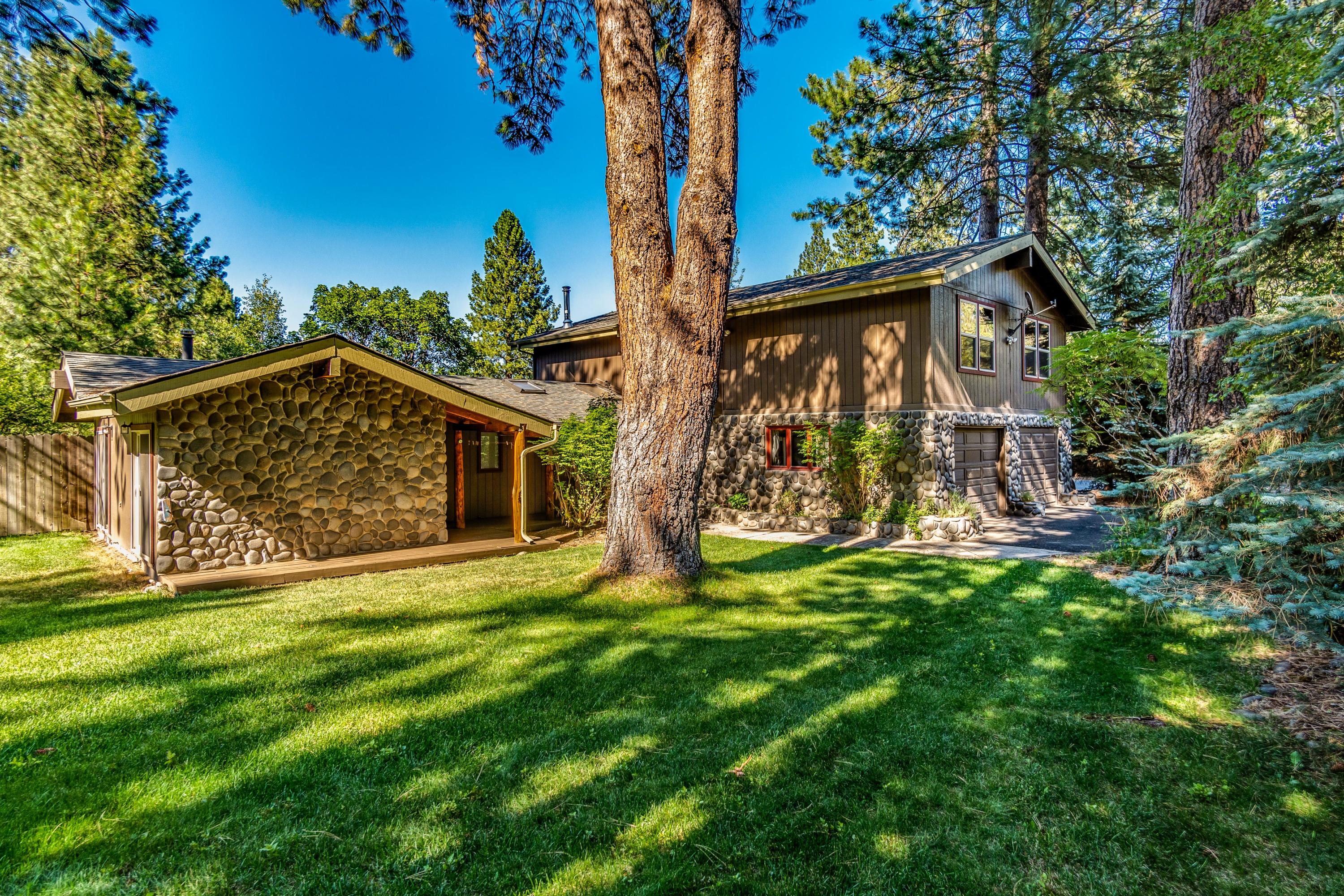 Properties like this one do not come along very often! This fun, well built, & carefully thought out property is on almost 6 acres (w/2 acres of irrigation) right in the heart of SW Bend. The selection of use for the acreage is undoubtedly limitless. Whether you are looking for a place to run your business & work from home, or are a hobbiest/craftsman, needing to store your toys, garden, run a mini farm, and/or let your loved ones play, this is your place. This custom & spacious 4 BD, 3 BA home offers a fantastic & private master on main w/large fenced side yard, an open floorplan w/vaulted ceilings & high end quality hardwoods, cabinets, counters, SS appl's, an open loft/living bonus & so much more. Property offers multiple outbuildings, including a 400 SF garage/barn, a 440 SF office/studio w/cork flooring, & a hobbiest dream 32'x40' Shop w/ custom built ins, as well as a studio w/full bath above. Don't miss this opportunity to see what is hidden in the trees w/ this unique property.