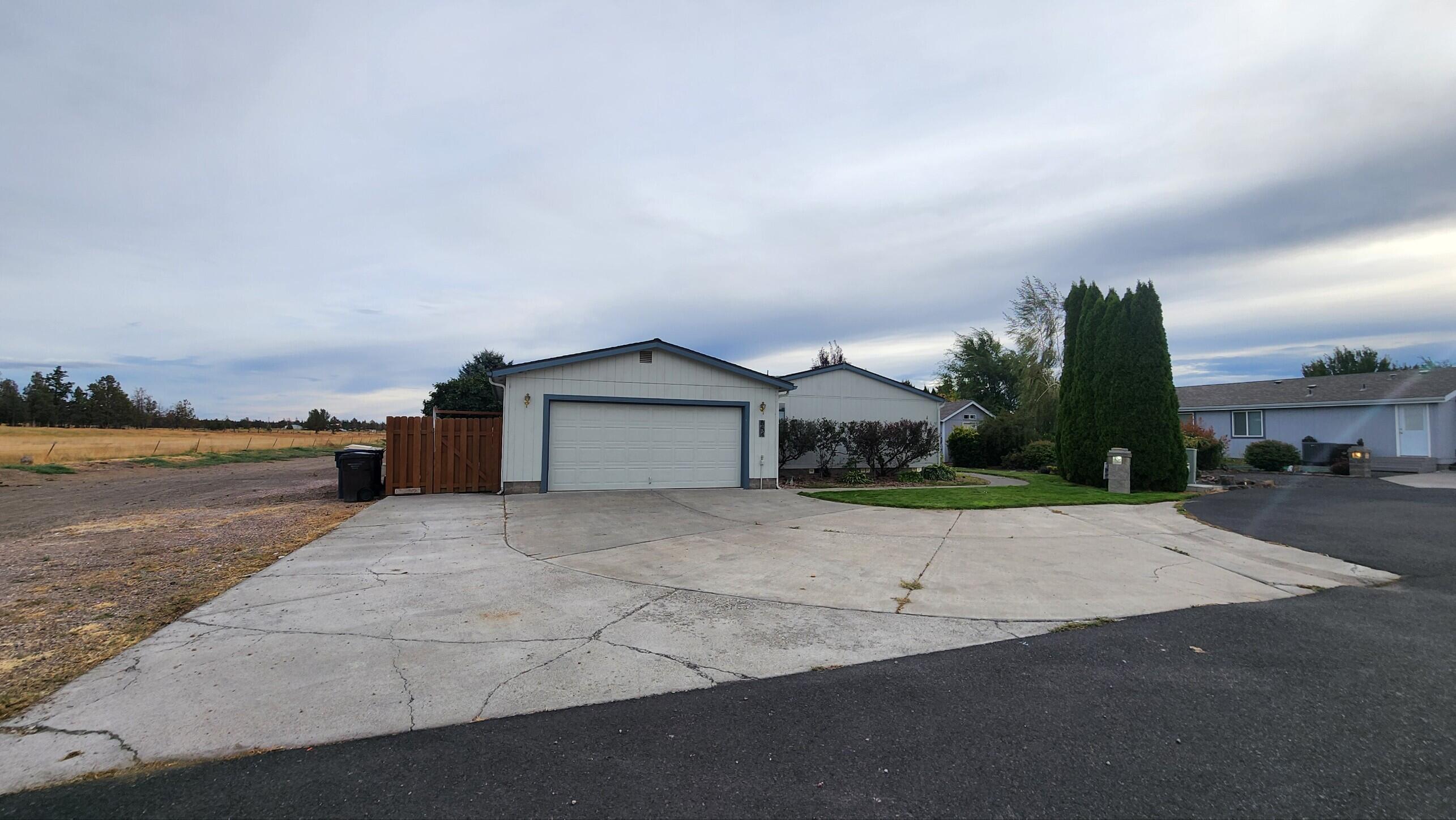 Located at the end of a cul-de-sac on the edge of the Redmond city limit, this cute house is waiting for you to call it home. Boasting a large, over-sized 21x27 fully finished garage with plenty of power for the car guy or woodworker. Outside, you will find a wide, flat driveway with extra parking and alley access to the back yard to park your toys or trailer. Cozy up inside with the pellet stove or with the heated/jetted tub in the primary  bathroom! No projects inside thanks to a fully renovated interior, finished in 2022. The renovation left nothing untouched, including, custom cabinets, flooring, granite counters in the bathrooms and butcher block in the kitchen, hand textured walls, tiled shower walls and new appliances. Enjoy this quiet neighborhood and the view of Smith Rock from the driveway, while still being close to schools and shopping! Seller is a licensed Real Estate broker in the state of Oregon