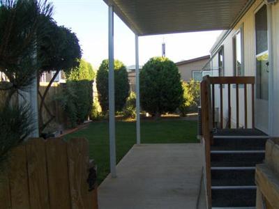 Adorable manufactured 2 Bed/2 Bath 1056 sq. ft. home, situated on a private corner space in park & features large kitchen w/lots of cabinetry, built in china hutch/buffet, vaulted ceiling w/ceiling fan, formal dining (could be closed off for den or 3rd bedroom) new 55 gallon hot water heater, new air conditioning unit, covered patio, insulated shed w/electricity, raised garden beds, lovely landscaping and completely fenced! Space rent $300. $52,500