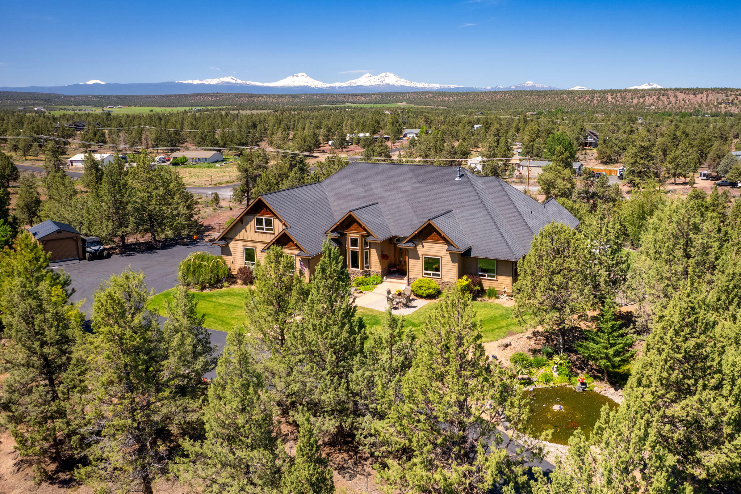 Discover unparalleled luxury in this breathtaking custom-built home on the bluff w/ spectacular Cascade Mountain views from Bachelor to Hood. Step inside the mahogany doors to soaring 28' ceilings adorned w/ exposed beams & complimented by floor to ceiling windows & hickory hardwood floors. The expansive open kitchen is a chef's dream, featuring granite countertops, double oven & wet bar. The primary bedroom boasts a vaulted ceiling, his & hers closets, and a spa-like ensuite with a tile shower + soaking tub w/mountain views. Above the garage, a spacious bonus room offers expanded living space. Outside, a tri-level paver patio w/ firepit invites you to enjoy the stunning surroundings, while a 17' swim spa provides year-round relaxation. Attractive black wrought iron fencing encloses the rear yard. Property also includes a detached ADU w/ ductless air, perfect for guests or additional living space. Experience the perfect blend of elegance and comfort in this Central Oregon paradise.