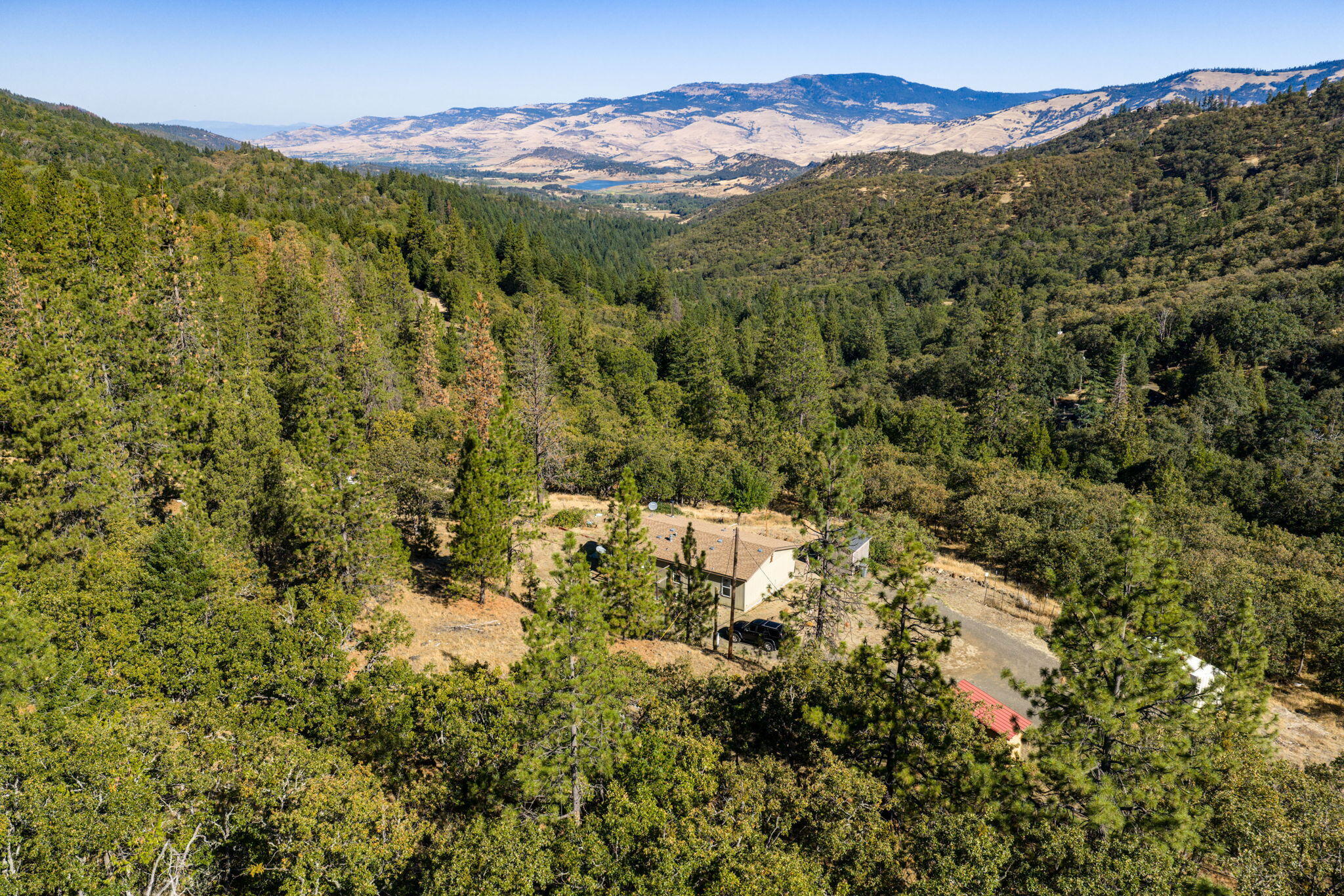 Just minutes from downtown Ashland, this 4.14-acre retreat blends privacy, natural beauty, and convenience. Nestled on a gentle hillside, the 2012 manufactured home offers 3 bedrooms, 2 baths, and 1,119 sq ft of light-filled living space. With sweeping views of Emigrant Lake, rolling hills, and the surrounding mountains, this property  creates a sense of peace and connection with nature. The property is comprised of two tax lots, providing added space and flexibility for gardening, animals, or future possibilities. Its desirable location offers the best of both worlds—quiet country living with easy access to Ashland's shops, dining, and cultural life, plus endless recreation just minutes away. Whether you enjoy hiking, skiing, exploring wilderness trails, or simply savoring the tranquility of your own land, this property offers an inviting canvas for your Southern Oregon lifestyle.