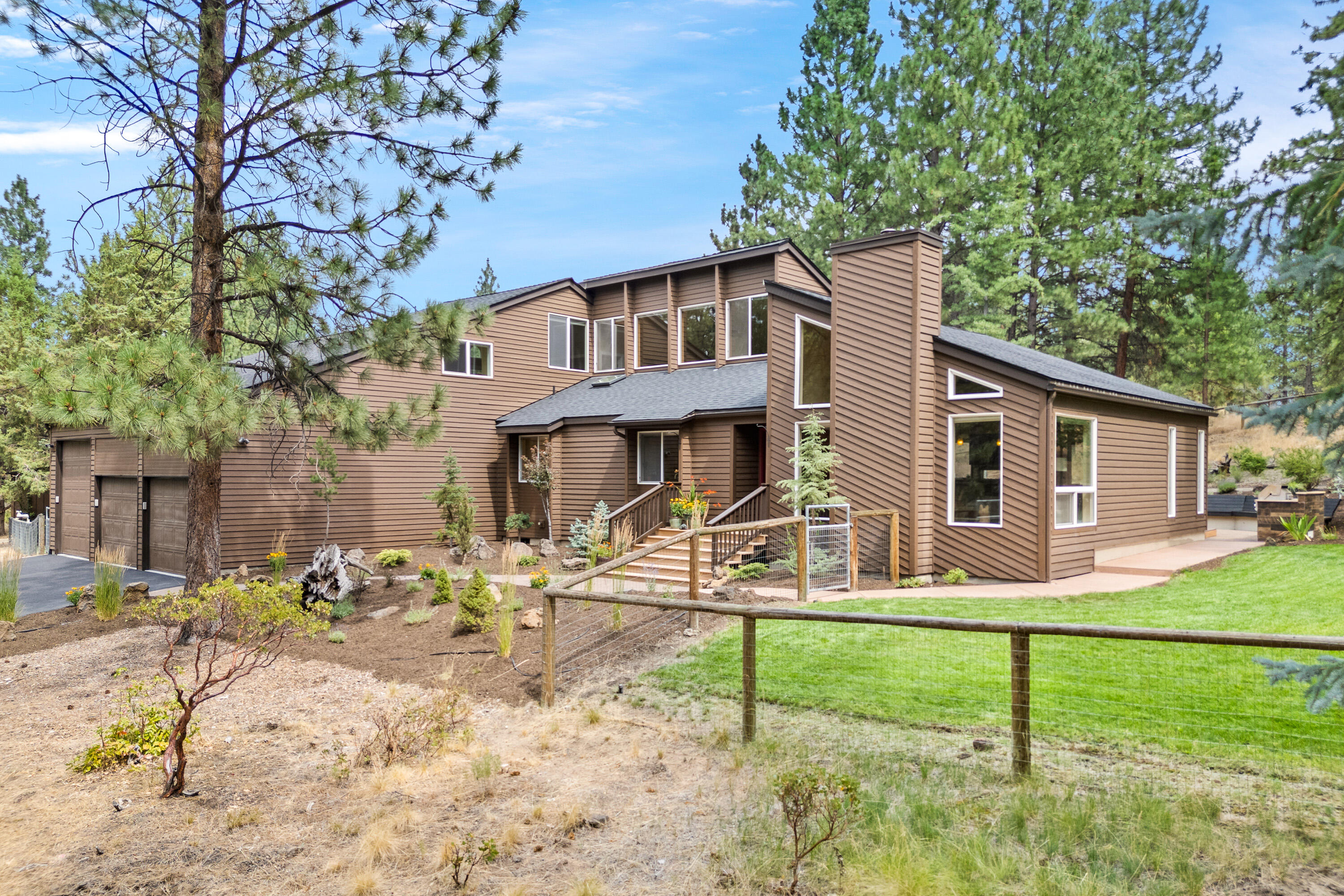 Woodside Ranch home offers SINGLE LEVEL living on 2.58 acres in private setting.  Light & bright with vaulted ceilings & abundant windows. 3 of the bedrooms & 2.5 baths on the main level.  Upstairs provides spacious loft & bonus room/4th bedroom w/private deck. This home was updated 2022-2023 to include new roof, all new flooring, kitchen appliances & heat pump.  Ductless heating/AC was added upstairs last year.  Beautiful wood floors throughout the main level & loft with tile floors in the baths.  Spacious kitchen with eating bar, granite counters, designer lighting, gas range w/air fryer & instant hot water.  Both the living room & family room have gas fireplaces. Primary suite with door to private deck, walkthrough closet, soaking tub, dual sinks & tile shower.  Enjoy the paver patio w/built-in BBQ & bench seat. 3-car garage with B-class RV parking bay & electric car charger. New 12 x 16 green house plus storage shed. Low maintenance fenced yard w/native plants. Room for an ADU.
