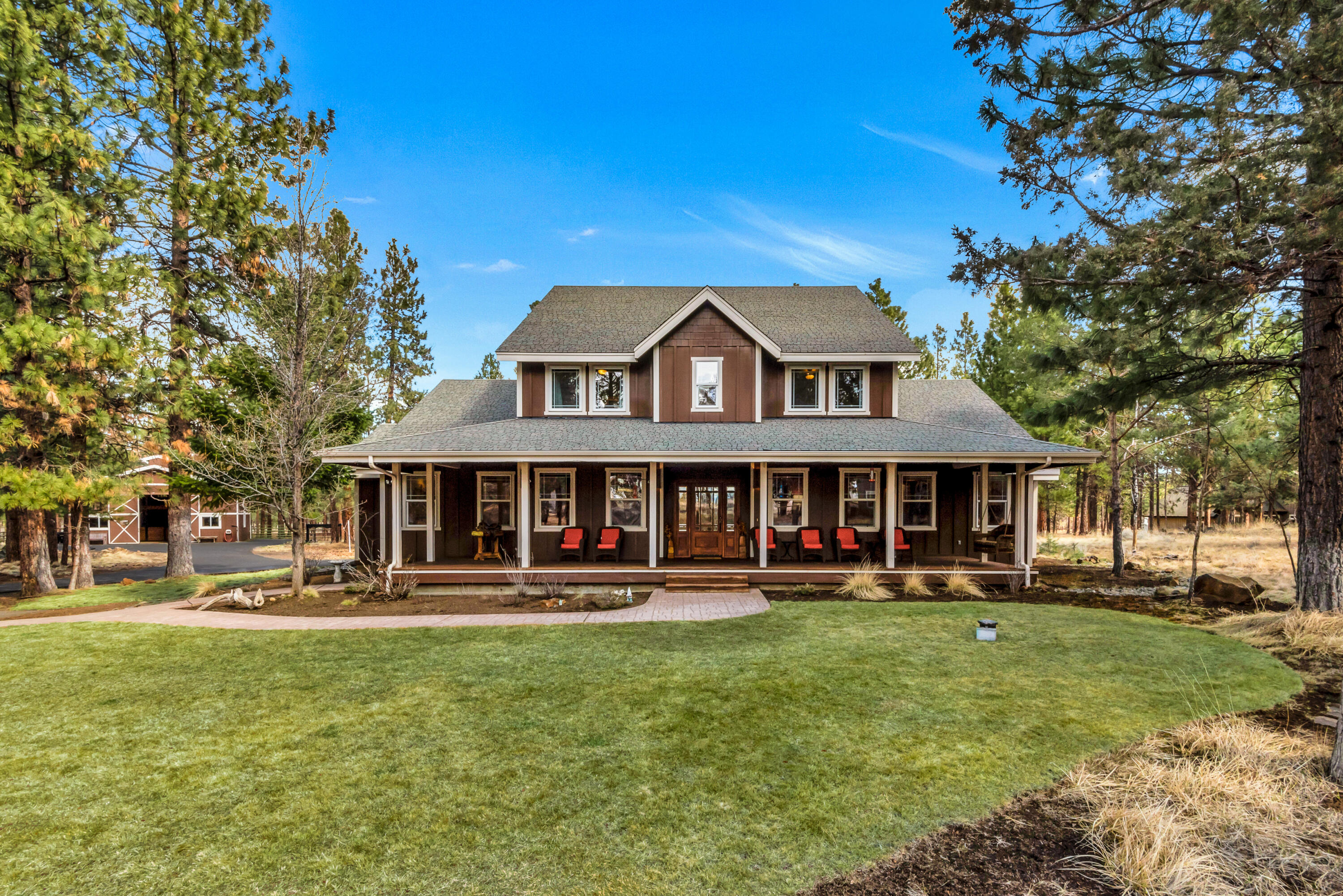 Escape to serenity with this exquisite property bordering the National Forest. This custom home offers the modern amenities of newer construction coupled with the classic charm of a bygone era. The main level is grand, with a large master suite, office and ample space for entertaining and relaxation. The great room is the centerpiece of the home, boasting a magnificent river rock fireplace and a soaring open-beamed ceiling. The country-style kitchen is equally impressive, with plenty of storage for all your culinary needs, a charming farmhouse sink and a functioning antique wood cooking stove. The upstairs features a second ensuite bedroom, two additional bedrooms with a Jack and Jill bath, and a bonus room. Enjoy gorgeous, unobstructed views of Broken Top and the Three Sisters mountains from the spacious front porch.  With 35 private acres of lush forest and trails, a 3 stall barn with a tack room, hay loft, workshop, and 140 X 200 riding arena, it is sure to be a horse lover's dream.