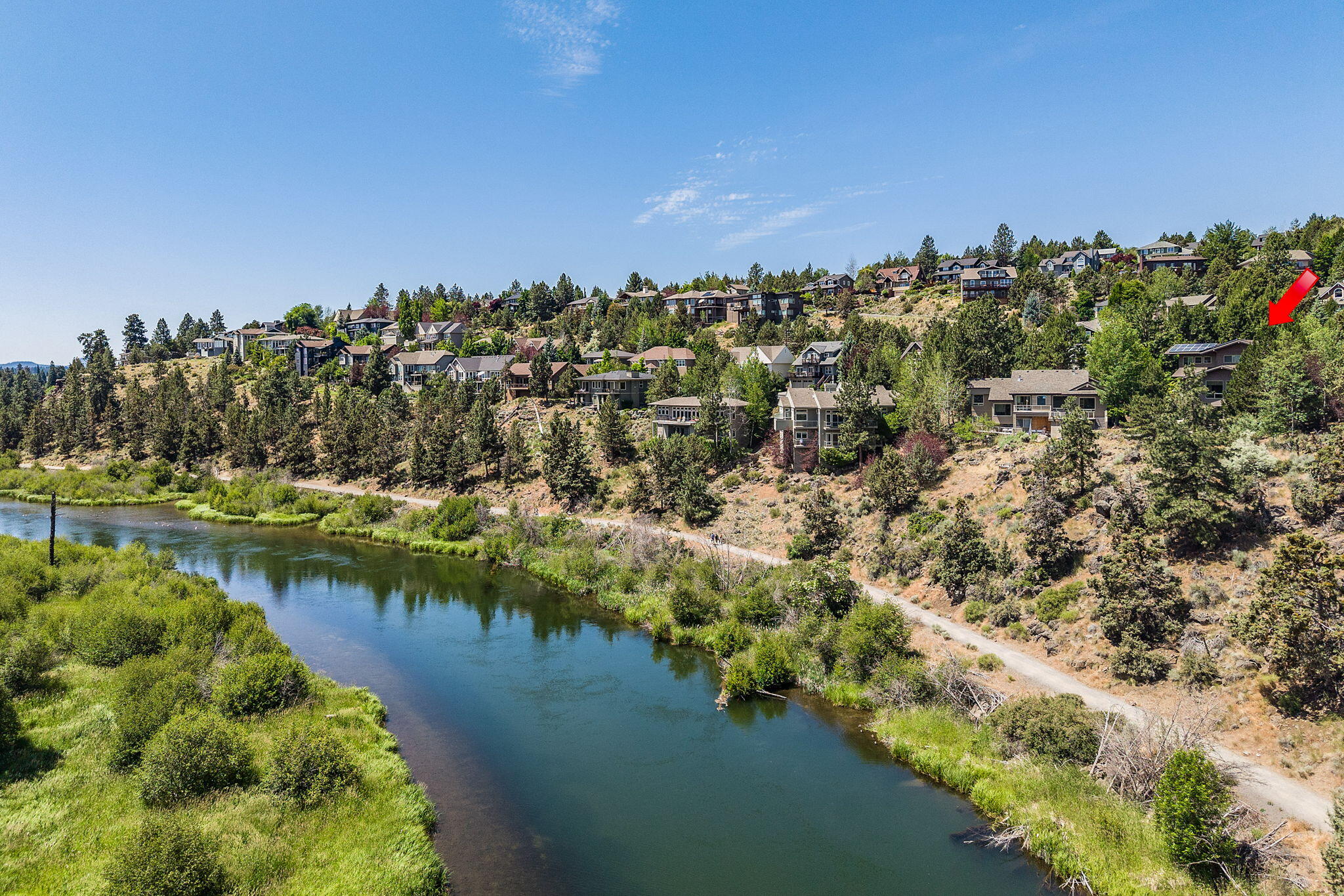 Seller will credit Buyer $20,000 at closing. 

Perched above the Deschutes River Trail, this Westside Bend home showcases panoramic river views and seamless indoor-outdoor living. A verdant walkway leads to the entry or around to expansive outdoor spaces. Inside, the open great room frames the river and treetops in every season. The kitchen offers an island with seating, a large pantry, and abundant storage. Guest suites are on both the main and upper levels, where you'll also find an office nook and a spacious primary suite with a luxury bath and hot tub deck. The lower-level bonus room opens to tiered private patios with a fire pit and sweeping views of the river plus a front row to the Pilot Butte fireworks show! Tucked at the end of the street, the property features an oversized driveway for up to six cars, plus a 3-car garage ideal for a shop. From your door, stroll down to the river trail and parks, float the river, walk downtown and embrace the best of Bend living.