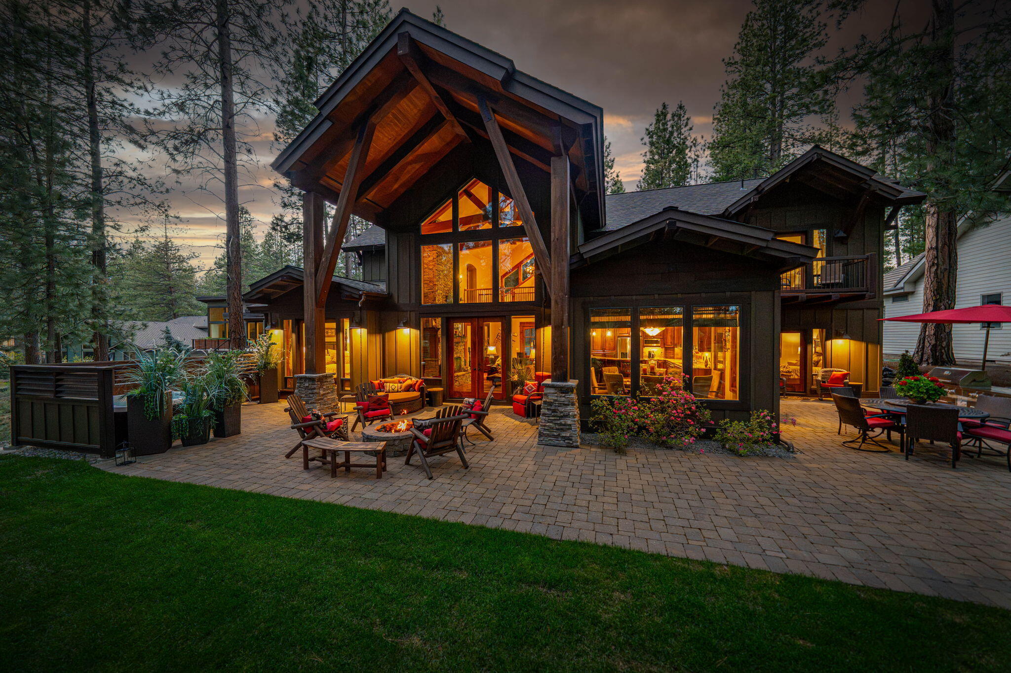 This 5-bed, 5-bath, 3,595 sq ft custom timber-framed home offers privacy, scale, and sweeping golf course views on a half-acre in gated Widgi Creek. A 175-ft driveway lined with emerald lawn leads to a light-filled great room with floor-to-ceiling fireplace, catwalk, and open kitchen with granite island, stainless appliances, and custom cabinetry. The main level features two en suites, including a spa-like primary with indoor/outdoor spa access. Upstairs are three more en suites and a media room. The patio includes a fire pit, BBQ, and spa with views of the 8th, 9th, and 10th fairways. Minutes to Mt. Bachelor, Cascade Lakes, and Downtown Bend.