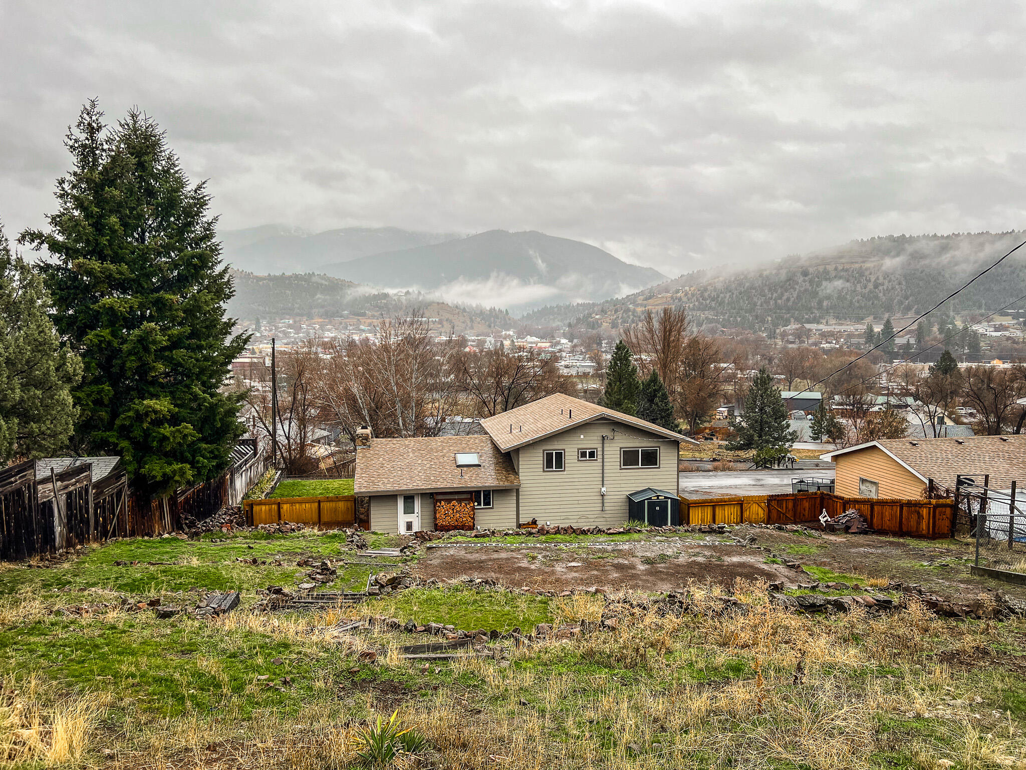 This move-in ready home offers views of the valley and Canyon Mountain. You can step into a spacious great room, measuring approximately 767 square feet, which features a wood-burning fireplace and a bartop that is perfect for entertaining.

On the upper floor, you will find three bedrooms, two bathrooms, and two linen closets. The primary suite boasts two closets and a sliding barn door that leads to the primary bathroom, which includes a tile shower and a double vanity.

Downstairs, you will discover a generously sized laundry room with a half bath, as well as an office or a nonconforming fourth bedroom with acid-stained concrete floors. Your attached garage, approximately 338 square feet, is extra deep and equipped with a built-in workbench and shelving for use as a workshop.

The home underwent a remodel in 2018, featuring Hardie siding, a composition roof, and interior updates. Additionally, the ducted electric furnace was replaced approximately three years ago.