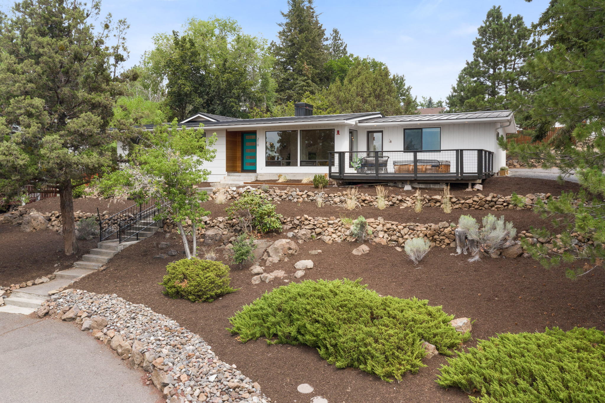 Tranquility abounds at this modern single level home featuring a roomy double lot on a quiet & peaceful street. Views of the Old Mill and sparkling city lights on Bend's West side. Moments to First Street Rapids & Deschutes river trails. 

Cultivate your culinary flare in the updated chefs kitchen w/ gas range, quartz counters, pantry & S/S appliances. Lovely dining area with wet bar overlooks private fenced back yard. Enjoy movies in the spacious family room highlighting a modern cozy FP, built-ins, & a Murphy Bed.  
Hardwood floors and wood burning fireplace are  at the heart of the open concept floor plan. Both baths are nicely updated. 

The primary suite has a large walk-in closet, skylights, vaulted ceilings and a separate office/flex space with french doors to back yard. 

Exterior features a newer metal roof & a 2 car oversized detached garage to store all your toys!

Relax on the cozy front deck or in the hot tub & take in the views. Don't miss out on this amazing opportunity!