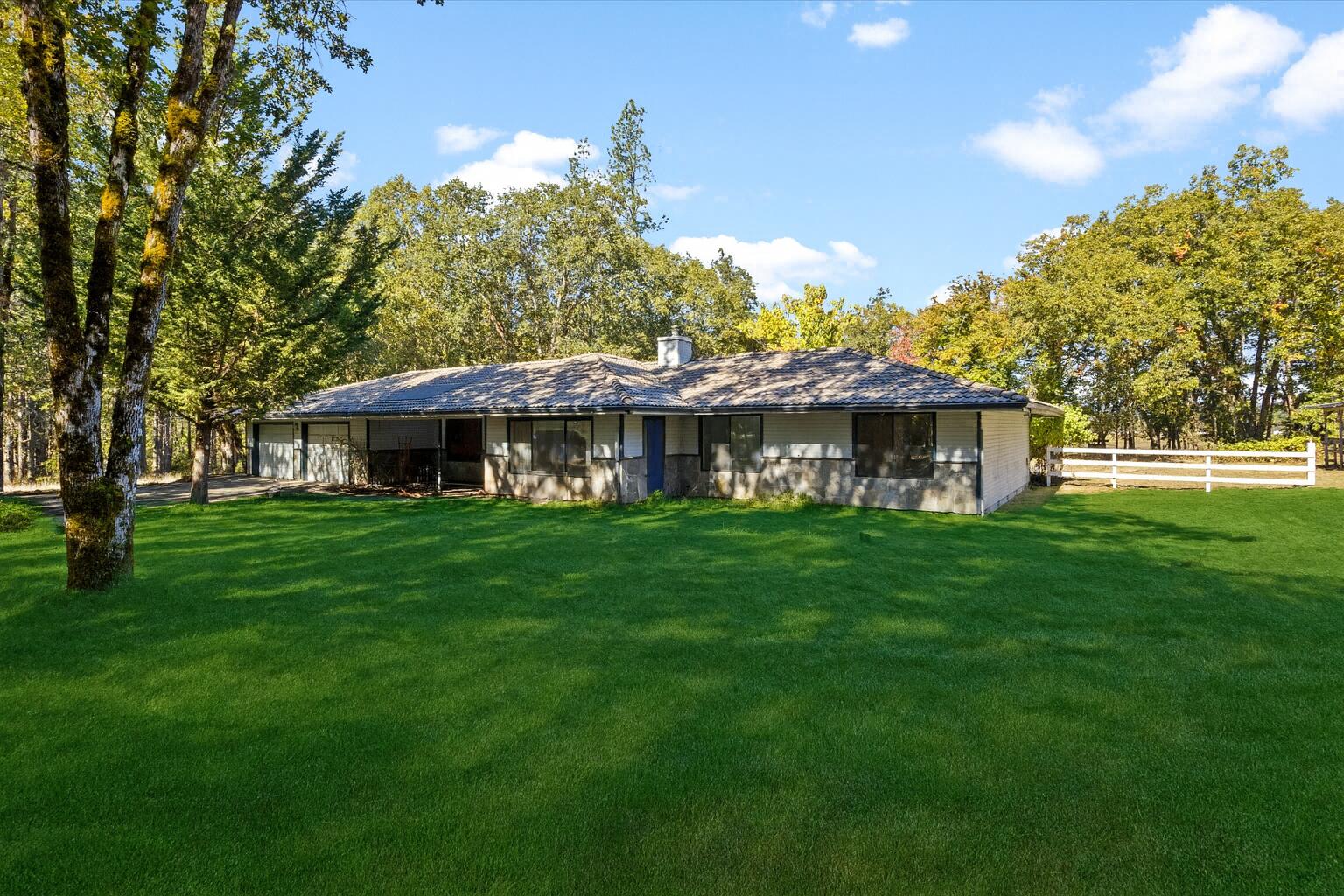 Discover peaceful living at 1080 Ferry Road, a spacious 3-bedroom, 2-bath home with 2,290 sq. ft. set on 9.44 private acres along the scenic Rogue River. This one-of-a-kind property borders BLM land, offering direct access to nature, hiking, fishing, and endless outdoor adventure right from your backyard.

The home features an inviting open layout with large windows that capture tranquil forest and river views, a bright country kitchen, and a cozy living area perfect for entertaining or relaxing. Enjoy the serene sounds of the river, abundant wildlife, and the privacy of a secluded retreat just minutes from town.

Out buildings include multiple animal stalls, attached garage, detached shop, and tractor shed.

Water rights from the Rogue river!

With flat usable land, mature trees, and proximity to the river, this property is ideal for those seeking a lifestyle that blends comfort with the beauty of Southern Oregon's outdoors.