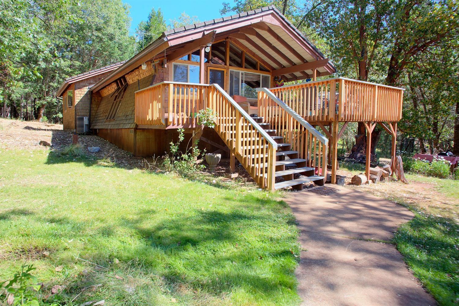 Are you looking for off-the-road privacy? You have found it! Situated on 11.55 acres of beautiful pastures and trees is a unique and charming country cottage. Sit out on the front deck overlooking lawn and gardens, then enjoy your 2 bedroom/2 bathroom home complete w/custom counter-tops, wood floors and a private deck off the master bedroom. There is a 2- story shop/garage for your projects and storage w/attached carport. Additionally, there is an adorable studio, currently rented. For the animal lovers, there is a small barn w/a corral. Most of the property is fenced w/3 separate pastures, each 2-2.5 acres. And a large fenced garden area and a small garden shed, as well! Gardens and lawn are watered by in-ground sprinklers. Outreach Satellite, equipment owned & installed. Main house roof is rubber-backed metal shingles. Don't miss out on this unique, hard-find-property! Call today!