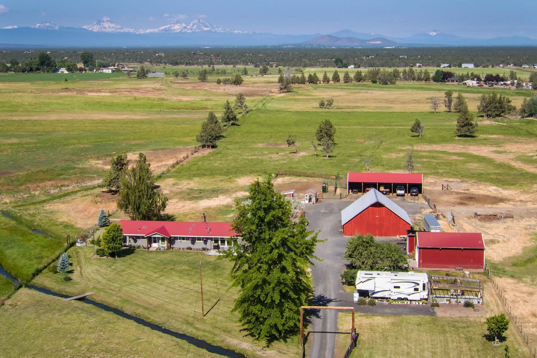 Cascade Mountain Views from country home in the heart of Central Oregon. Property is 35 acres with 32.79 acres of COID water rights, pond, fenced, cross fenced and corrals. Ranch style home is updated throughout, 2166 sq ft, 3 bedrooms, 2 bathrooms, single level, dining area, large kitchen, office and open floorplan. Living room has beautiful views and wood burning fireplace. Family room includes a juniper bar and wood burning fireplace. Landscaped yard, garden, greenhouse and chicken coop. Outbuildings include: two car garage, Shop with workbench, Red Barn, equipment shed and full RV hookup. Located approximately 10 minutes to Redmond or Prineville. This property is well maintained and ready for livestock!