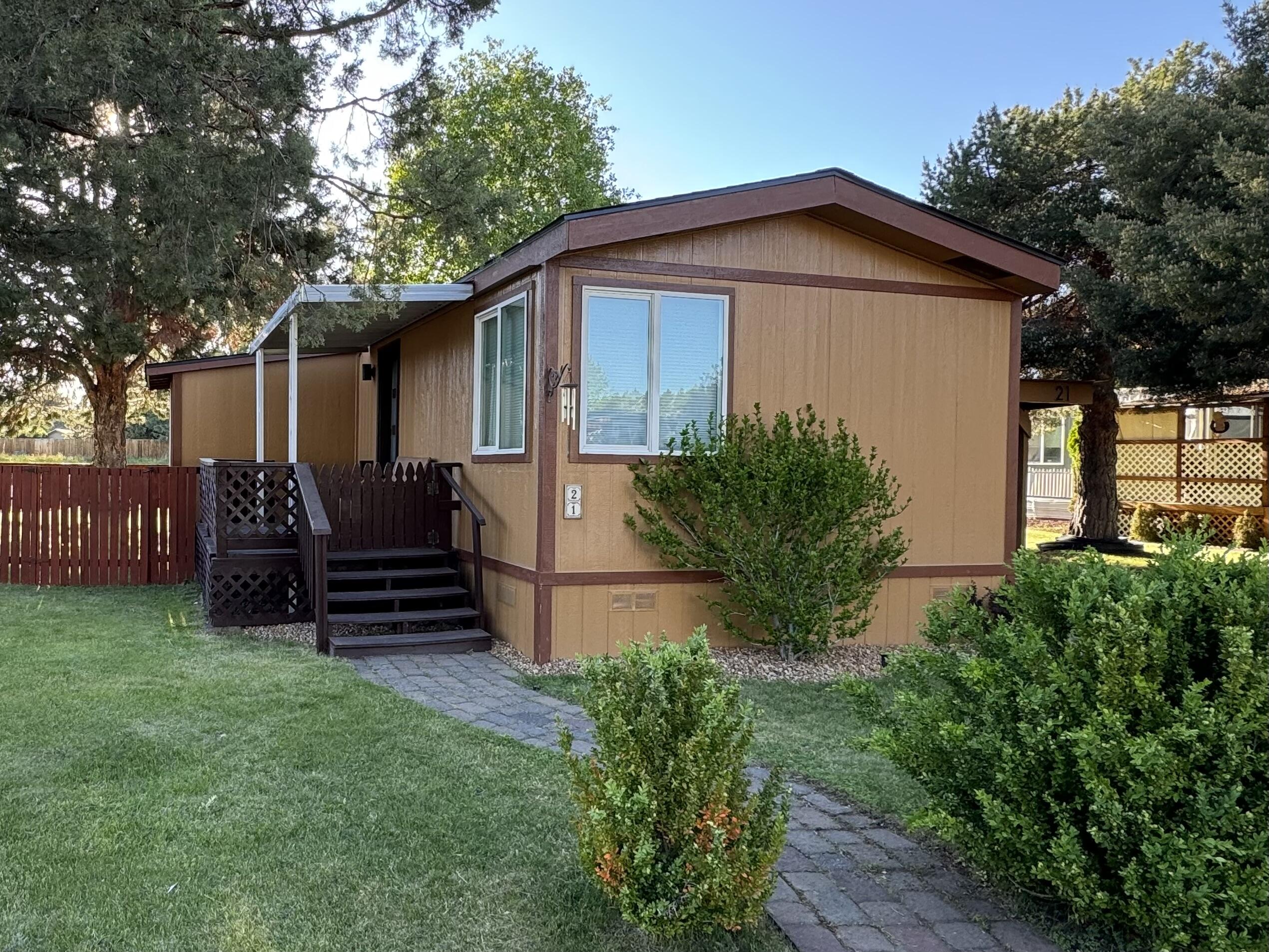 This wonderful, bright, and contemporary manufactured home is a rare find with two bedrooms and an office.  With extensive interior renovations, serene location, and proximity to the vibrant Reed South development, this home offers the perfect blend of comfort, convenience, and modern living.  Whether you are looking for a peaceful retreat or a place to entertain this home has it all. Fully fenced yard, mature landscaping, and a covered front porch provides the sought after indoor/outdoor lifestyle.  This gem of a property underwent extensive renovations and upgrades in 2022: New electric stove, carpet in bedrooms, vinyl plank flooring, modern window and door trims, matching hardware throughout, contemporary window coverings, black out blinds in the bedrooms, electronically controlled blinds in the primary bedroom, and the list goes on.  See attached list for additional upgrades.  Large storage shed adjacent to carport.  Monthly space rent includes water, sewer, street snow removal