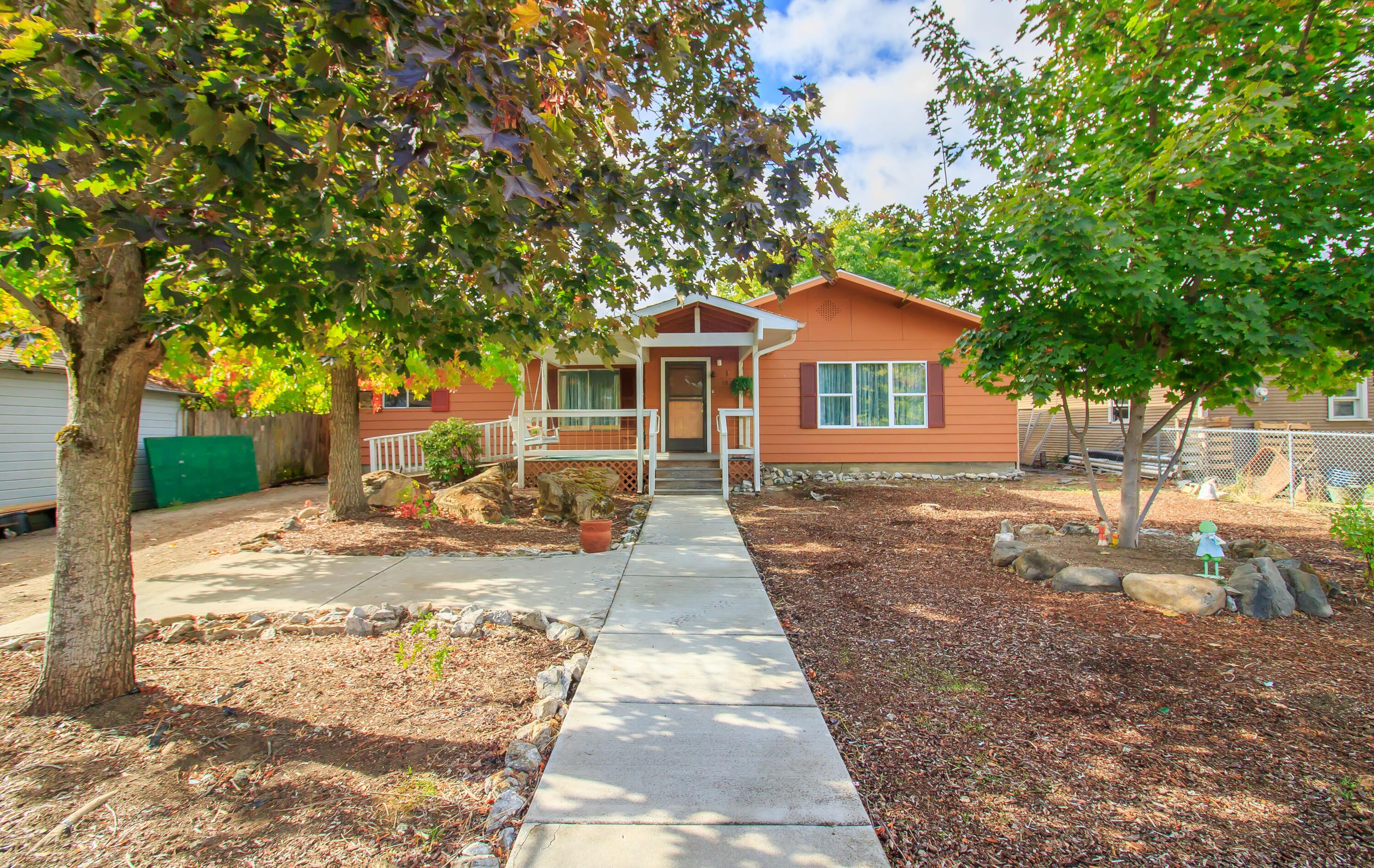 Enjoy your morning coffee on the front porch as you welcome a new day.  There's so much potential in this 4 bedroom/2 bath home. Waiting for a buyer's TLC and updating touches. The split bedroom plan offers versatility. Newer double paned window in living room. Wood look vinyl flooring in dining & kitchen and newer carpet in living room. Some interior and exterior painting completed in the last 4-5 years. Large, fenced front yard. In the back you'll find patio space, shop and carport that is accessed off the alley. Easy distance to elementary and middle schools. Only two short blocks to the post office, market, coffee shops, and several unique dining experiences.