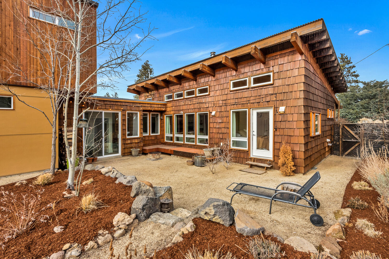 This one of a kind property cannot be missed! Blending an arts and crafts design ethos with modern lines, the soul of this property is palpable from the moment you arrive. The single level primary home benefits from incredible southern exposure, flooded with light and warmth through a soaring wall of windows overlooking a sun deck, patio and mature landscaped backyard. The home features local 1 inch solid pine floors, poured concrete countertops, western cedar slabs and flagstone bathroom floors with radiant heat. The recently constructed ADU with private entrance makes for the perfect investment, detached home office, private guest quarters or accommodations for multi generational living. Hand painted floor tiles, quartz counters, efficient heating/cooling system, lock off storage and southern facing deck, all elevate the ADU and add to the magic of the property. This westside gem sits just blocks from the Deschutes River, Galveston corridor, shops at the Westside Yard and downtown.