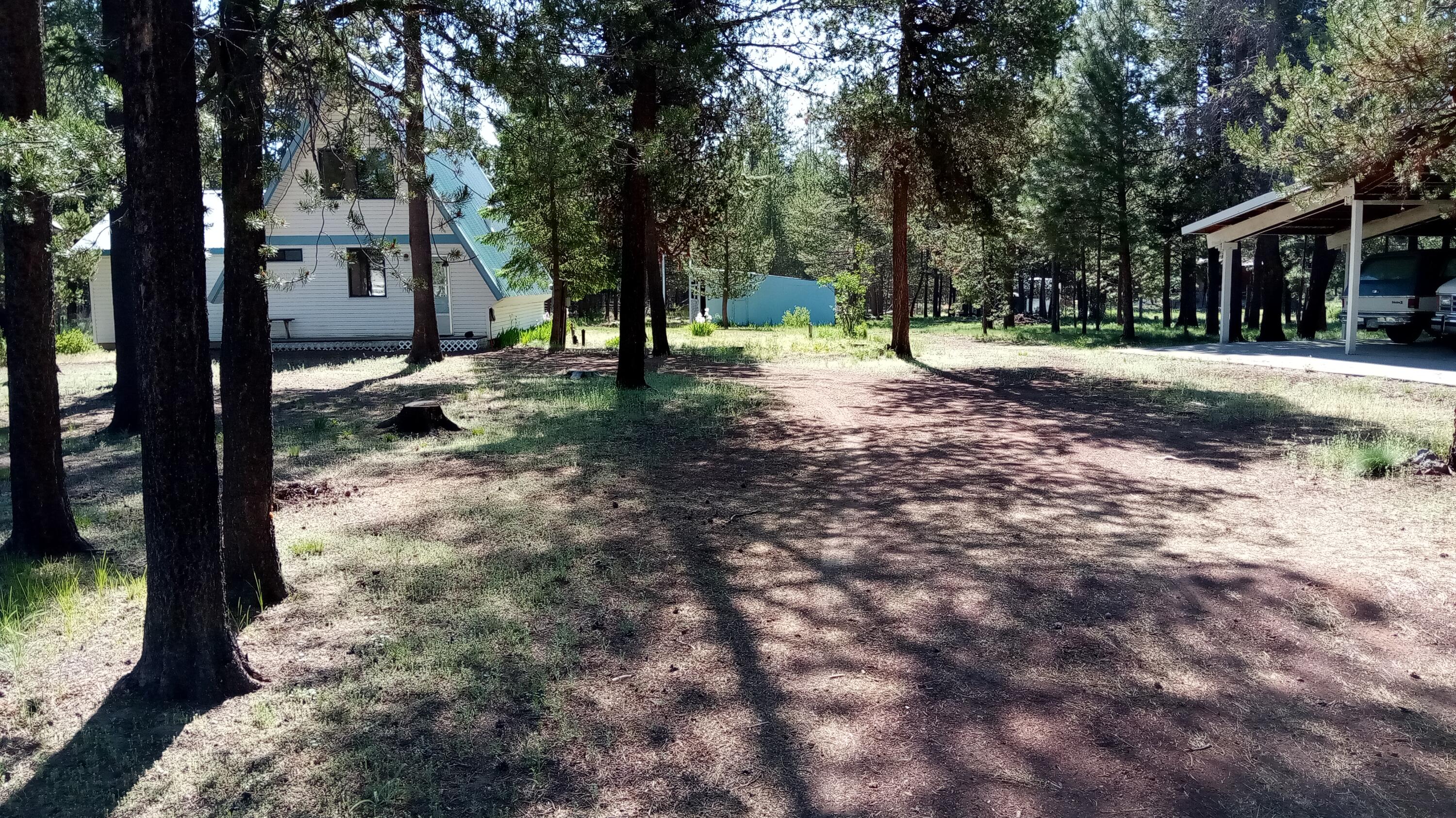 Back on Market, No fault of property/seller...Priced to sell...great opportunity to personalize. This sweet rustic A-Frame cabin in the woods has exposed pine walls/ceilings, Great Room with deck access, 2 full bathrooms, 2 bdrms up and large primary with deck access on the main floor.  Rustic interior with lots of opportunity to update and finish the way you want. Update for full time living or recreation use. Spacious 1 acre wooded lot has a 720 sq ft garage/shop with 1/2 bath, loft area and covered lean-to structures, both with concrete pads, on each side. One lean to with RV hookup, add'l RV hookup in yard. Quiet area close to town but private setting. Metal roofing on both structures. Small storage shed in back yard. Make an appointment to see this diamond in the rough TODAY! Private well needs new pressure tank. Works fine but pressure fluctuates. New concrete septic tank. Perfect vacation get away or live here full time and enjoy all the outdoor recreation La Pine is famous for