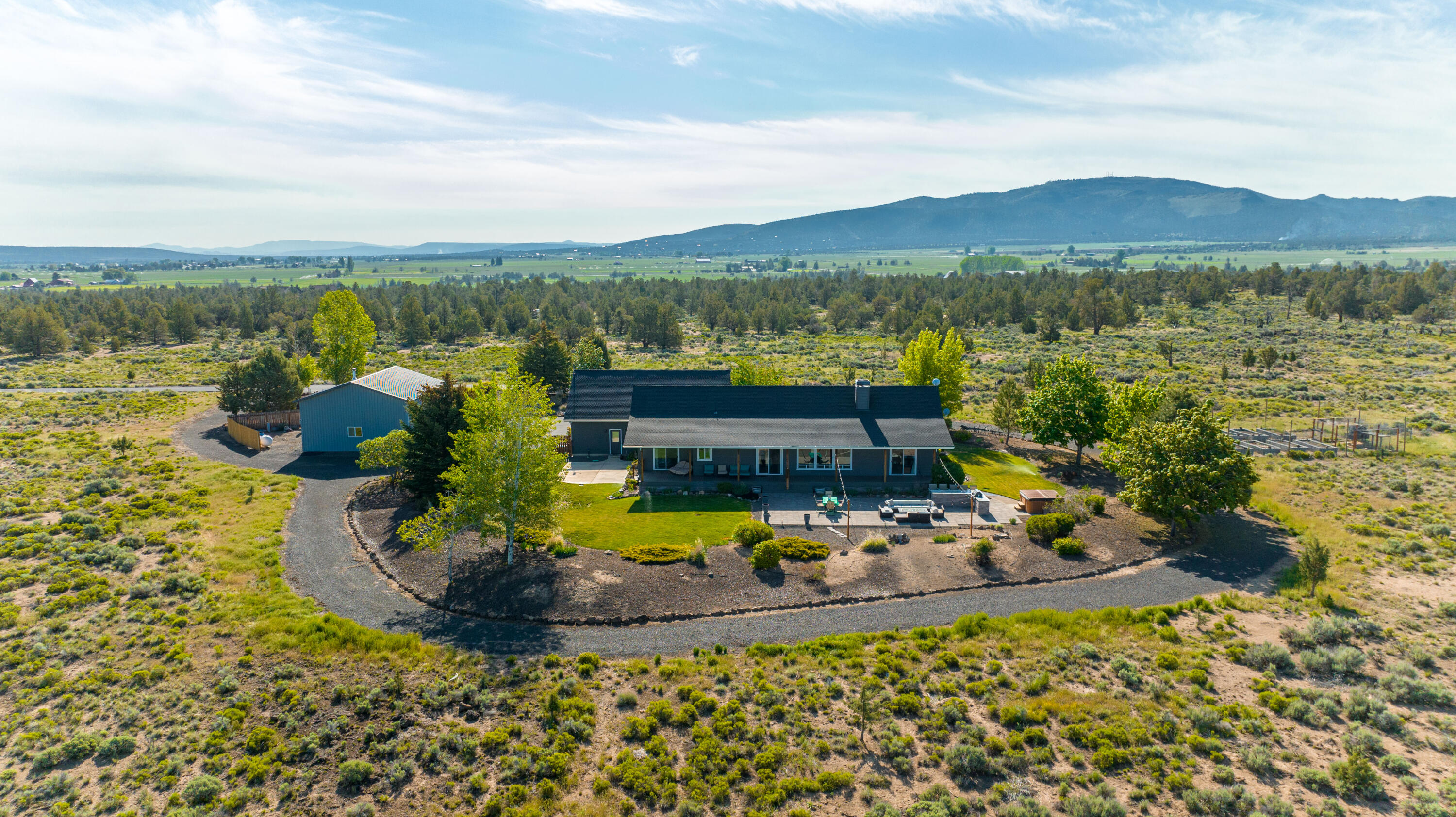 Stunning sunsets and awesome sweeping Cascade Mtn. views are standard at this one-of-a-kind contemporary ranch home in beautiful Powell Butte. Peaceful 21+ acres abutting BLM, with access to 1,000s of acres of adventure. This well redesigned, single level home includes an open great room with rock fireplace & expansive windows that capture the view, as well as an updated kitchen w/large quartz center island, SS appliances & pantry. Primary suite includes 2 walk-in closets & dual vanity bath. There are 2 more bedrooms on the opposite side of the home & 4th bedroom/office/den provides flexibility in a house of this size. Outdoor living includes 2 covered composite decks, lawns, hot tub, deer fenced raised garden beds & chicken coop & paver patio w/outdoor kitchen built-in BBQ, L-shaped quartz island & cement gas firepit. 3-car oversized garage, RV storage/shop w/loft has 13' & 7' doors & 50 amp service. RV hookup & dump on site. A fabulous retreat minutes from Central Oregon's offerings.