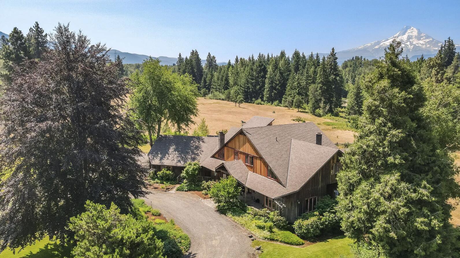 Elk Haven - A breathtaking 55-acre estate nestled in the Hood River Valley and the first time on the market for over 50 years. With commanding views of Mount Hood, low-bank frontage on the East Fork Hood River, and set up for the equestrian lover or discerning buyer looking to find the perfect estate, Elk Haven offers the future owner complete seclusion, yet only 15 minutes from the mountain town and recreation paradise of Hood River and 10 minutes from the town of Parkdale. 
Consisting of two separate and adjoining tax lots (3000 and 401) that are in the process of being partitioned, the 5,800 sqft main residence, swimming pool, pool house, and two-stall horse shed are located on the 45-acre parcel. The 1,300 square foot 2 bed/1bath guest home, 8,400 sqft covered riding arena, 3,200 sqft historic hay barn, 1,200 sqft four-stall horse barn and tack room, machine shop with garage, and chicken coop are on an adjoining 9-acre tax lot. Conservation easement held by Columbia Land Trust.