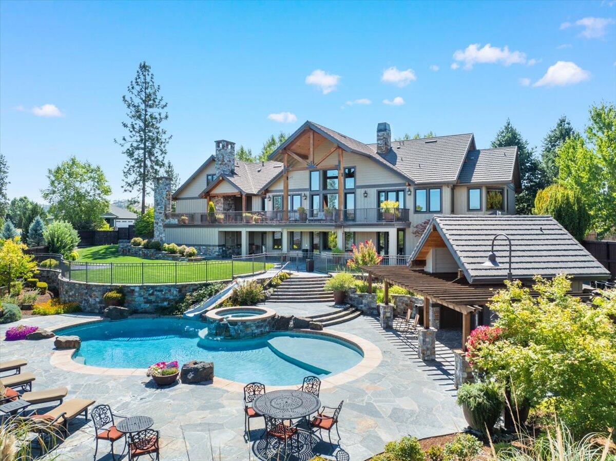 Stunning home in the prestigious Eagle Point Golf Community! Incredible swimming pool with rock slide, hot tub & pool house! Custom, solid wood, stained & glazed cabinetry & moulding! Basketball court, expansive views, hand selected rock features from Montana, metal fireproof roof & so much more! This sophisticated custom-built craftsman home boasts refined elegance throughout. Immaculate kitchen is designed for entertaining, complete with 2 islands, granite countertops, stunning alder cabinetry, & high-end appliances. Primary suite on main level includes a gas fireplace & an ensuite bath resembling an exclusive spa. Lower level is perfect for entertaining guests, boasting a large family room, game room, kitchenette, an indoor playhouse for kids, & 3 bedrooms, each with its own full bath. Outside, the back patio offers a luxurious outdoor living space, equipped with an outdoor kitchen, stone wood-burning pizza oven, & wood-burning fireplace - making it the perfect outdoor oasis!