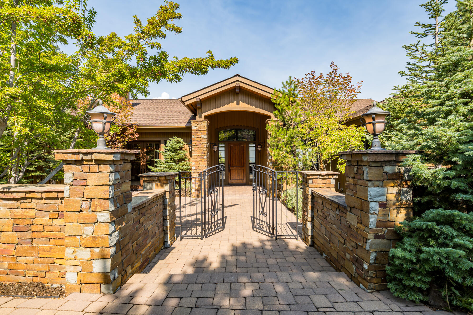 Nestled on a beautifully landscaped lot on one of Awbrey Butte's finest streets, this Mountain Modern home faces NW with panoramic views of the Cascade range. Covered patios on both levels maximize the views, visible from nearly every room. Enter through a gated stone courtyard with a water feature to a great room with vaulted ceilings, a floor-to-ceiling stone fireplace, and expansive windows that frame 180-degree mountain vistas. The gourmet kitchen features hickory floors, high-end Monogram appliances, a granite island, and Three Sisters views, while the dining area with wet bar opens to the deck for seamless indoor/outdoor living. In the primary suite, balcony access and sweeping views complement a soaking tub, heated bathroom floors, and a walk-in closet. Additional spaces include 3 guest bedrooms (2 en suites), a media room/home office with stone fireplace and courtyard access, a potential wine cellar, and a 3-car garage. Recently upgraded with new exterior paint and carpet.