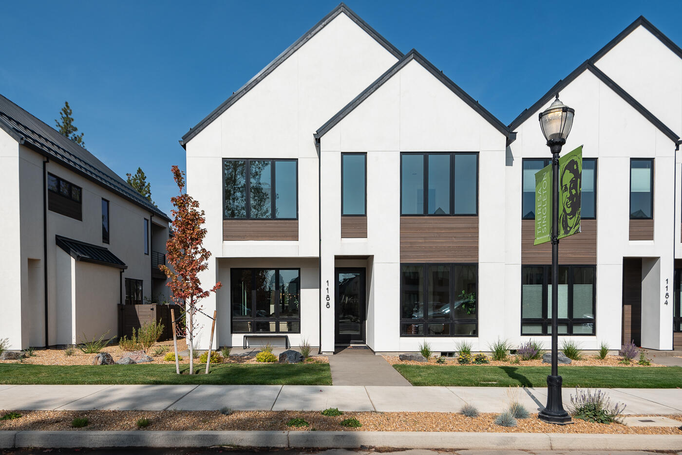 Scandinavian-inspired modern design with the award-winning craftsmanship of Structure Development NW in Discovery West. Trove Townhomes blend clean lines, contemporary finishes, and an open-concept layout, offering extraordinary living spaces. Great room with gas fireplace, custom built-ins and hardwood floors. Kitchen features professional appliances, large island and pantry. Dining area and covered patio are perfect for entertaining. Main level includes a guest suite, while the upper level is highlighted by a stunning primary suite with vaulted ceilings, tile shower, radiant floors and a large walk-in closet. Two additional bedrooms, full bath, loft, laundry room and covered deck complete the upper floor. Garage offers ample storage, and the fully landscaped yard enhances the home's curb appeal. Located just steps from Discovery Corner Plaza, a vibrant hub for shopping, dining, and neighborhood events. Embrace a carefree, active lifestyle in the heart of Discovery West.