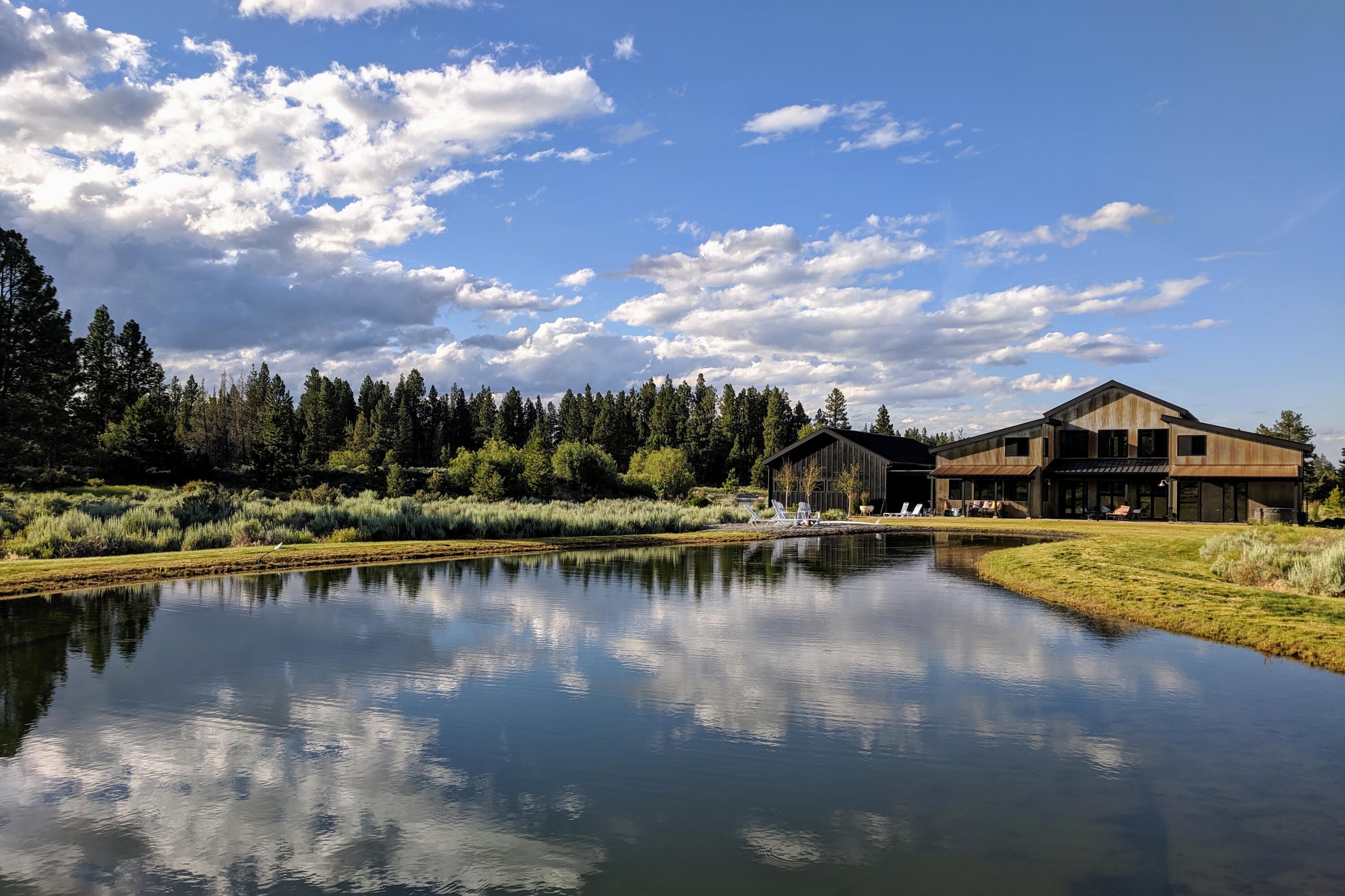 Nestled in a highly sought-after west side location with beautiful views, this 3,518 sq. ft. elegant mountain farm home sits on 40 acres of open space. This custom-built home embraces modernity and nature in one space, with an open-plan layout that blends seamlessly into the surrounding landscape. Thoughtfully curated design elements are present throughout every room. It features 4 bed, each with its own loft space, 4.5 bath, his and her powder rooms and closets in the primary suite, a 3-car garage with additional storage space, a custom media room, and top-of-the-line built-in kitchen appliances. Equestrian enthusiasts will appreciate the open-air barns with tack and hay storage and easy access to BLM land for long trail rides right off the property. The property also has an expansive pond near the home, perfect for paddle boarding, swimming, and sunbathing. This is a rare opportunity to live in a luxurious retreat with only the sounds of nature, all just 10 min away from downtown.