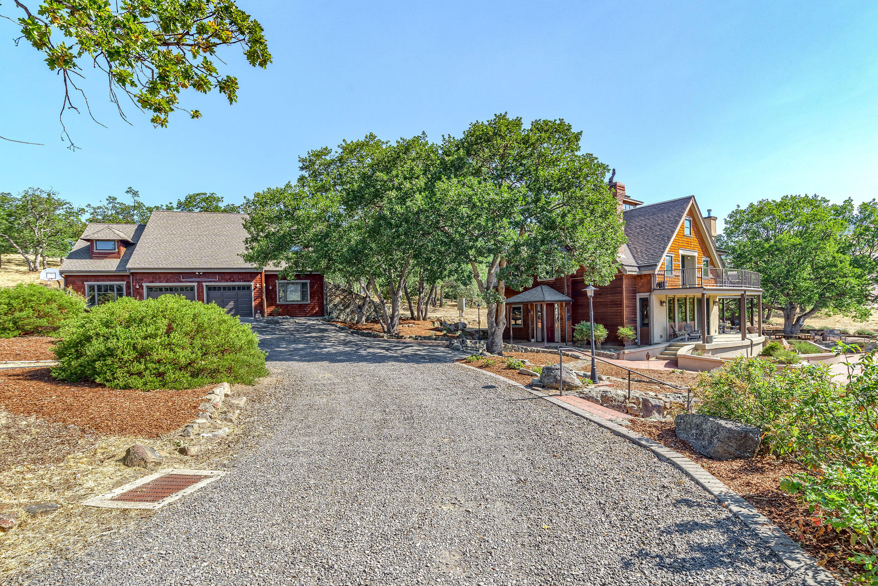This incredible Post & Beam masterpiece is a true labor of love. Located in the sought after, close-in rural neighborhood, you're sure to enjoy the convenient proximity to Emigrant Lake but also to downtwon. Included in the sale is a custom home, detached garage w/ a workshop, loft, spacious office & full bathroom. Light filled passive solar home w/numerous indoor & outdoor entertaining spaces. Hand hewn Cedar & Pine frame fitted w/ wooden pegs, brick, reclaimed doors, timbers from the 1850's and so much more. Radiant floor heat, a grand fireplace w/ custom rock surround as well as a Tulikivi masonry heater exude warmth throughout. Gorgeous second story owner's suite with balcony. Main level features a versatile layout including living & family rooms and a well appointed kitchen. Numerous brick patios, enclosed garden, TID irrigation for two acres. Views of Pilot Rock and Soda Mountain Wilderness.