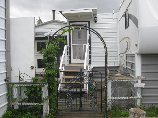 Ready to escape the city?  Here is a unique property that is ready for you to run to and room for your toys too. About a third of an acre with many storage buildings for your toys & more, a shop and a uniquely designed home that has a heat pump for warm winters and cool summers. Sit in the yard and enjoy the shade of the many trees around this home. Fenced and Gated for you to ''keep everything inside.'' Bring the toys and run to the dunes and have some recreation fun or just sit under one of the many trees on this property and enjoy a cool drink with a good book. Many possibilities.