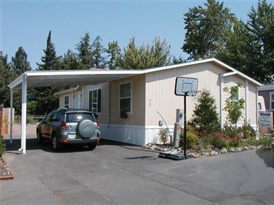 A Natural Inside & Out! This 2004 built 3 bdrm, 2 ba double-wide sports a new carport & shed in popular Wingspread Mobile Park. The vaulted ceilings give a sense of spaciousness to this step saving, open floor plan. The master suite, situated for privacy has a walk-in closet and bathroom that can be accessed from the laundry room. The kitchen-dining combo features rich, warm-toned cabinets & a built in china hutch. Have a green thumb? You'll find plenty of room to plant a garden in the wrap-around yard. This home is ageless in appeal and appeals to all ages!