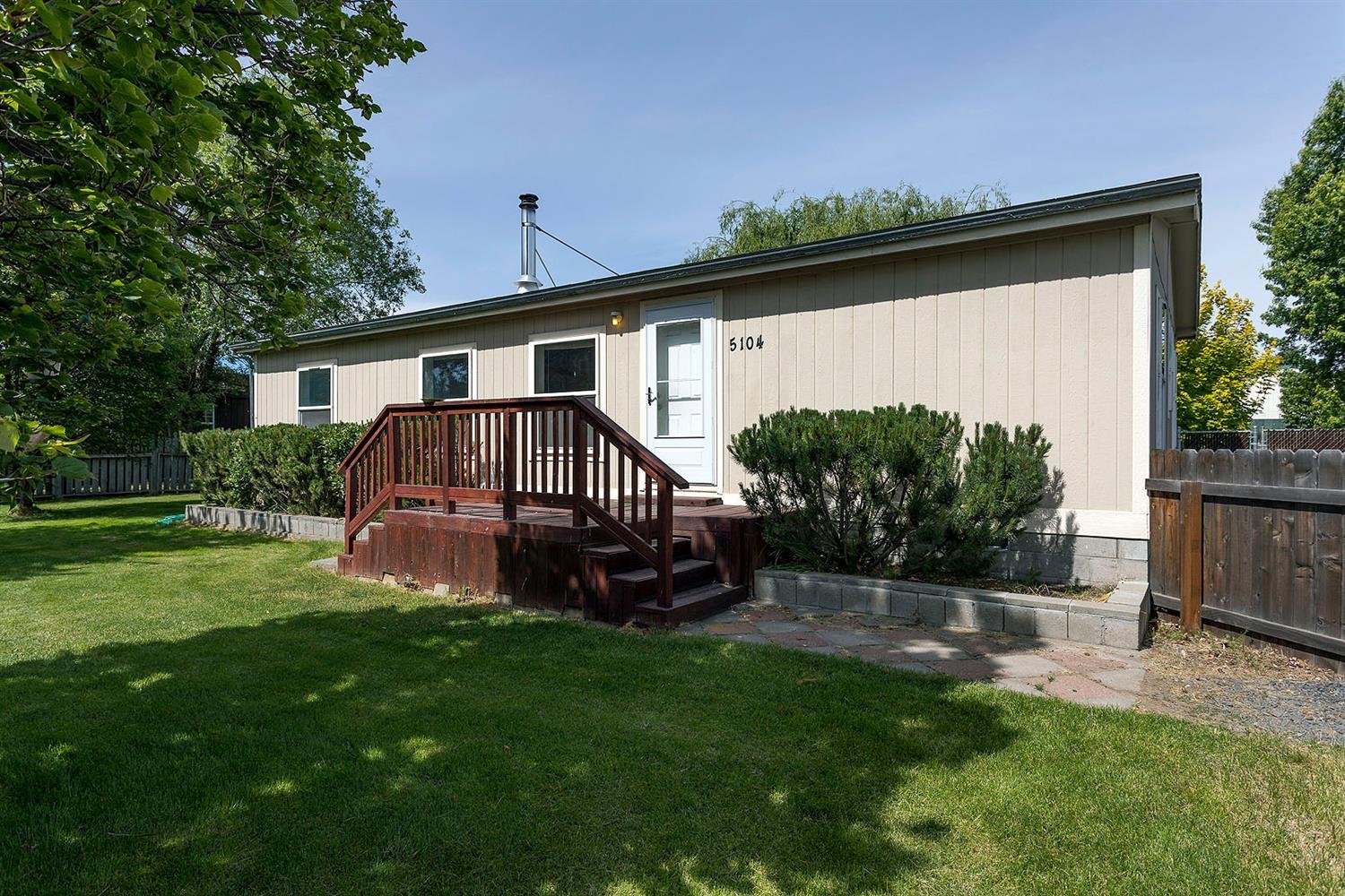 Park-like setting in the suburbs with covered back deck that looks out over a large .59 acre yard; mature trees including 10 fruit trees, berries, designated garden spot. A beautiful willow tree shades the deck. Detached oversize 2 car garage-30x32 is wired for 220 also includes a workbench and shelving. Lots of graveled parking area, including RV parking and power hook up. Ample protection for the toys, in the storage shed off the garage with power and lights. Close to schools. Master suite includes a walk-in-closet. Handy laundry room/mudroom area off the back deck. Open main living area with laundry. Open kitchen with large pantry. Certified wood burning stove is decorative as well as practical in the cooler months. Other features: drive through gate to the back yard, fully fenced yards, in-ground sprinklers in the front yard, auto garage door openers. KID irrigation with new 3hp pump. Upgrades include new bedroom carpets, new kitchen sink, some blinds, new storm door and tie downs.