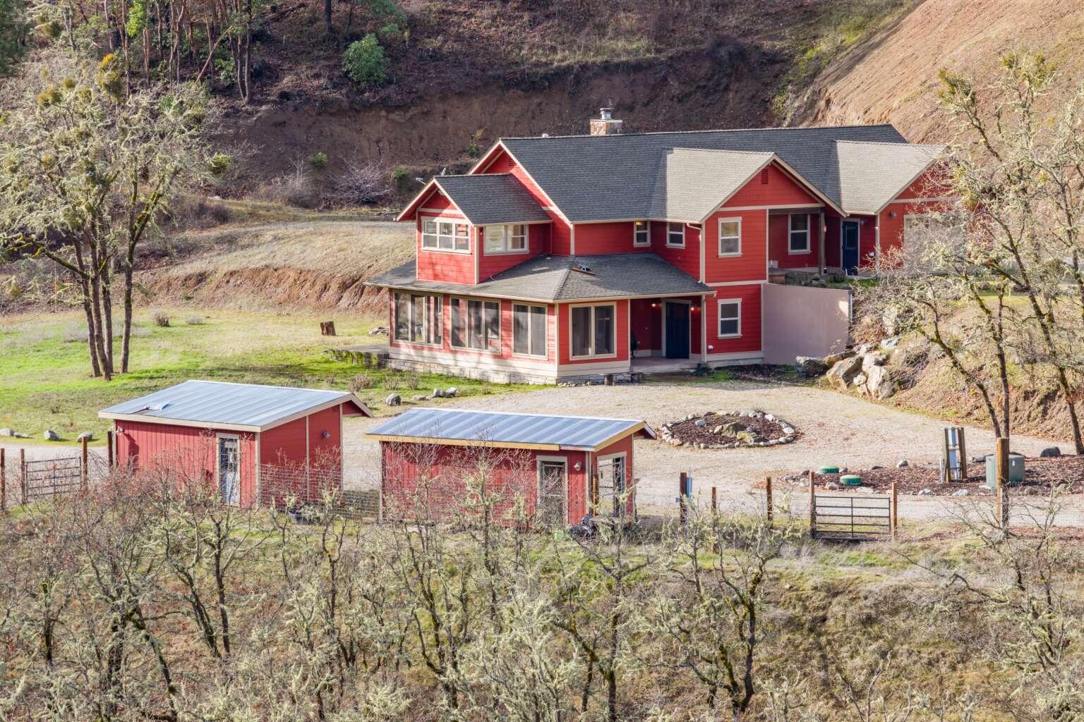 Beautiful custom home on 80 acres in sunny Southern Oregon. Property sits above the valley fog line and has many sunny days even in winter. Home has 2 primary suites, solid wood trim throughout, solid wood and stained concrete flooring, granite kitchen countertops, lots of windows for natural light, a screened in front porch, custom gun room, and much more. Home was constructed with materials sourced from the property. Outdoors has lots of parking/rocked area for equipment and material storage, irrigated pasture, fenced area for animals, 2 ponds, 2 wells, gold and fish bearing year-round creek, mature timber, historic mine tailings, etc. Multiple outbuildings - large, insulated 2-story shop, 2 light dep greenhouses, dog kennel, chicken coop, UTV garage. Excellent hunting, hiking, horseback riding opportunities. This property is the ideal self-sustaining homestead!