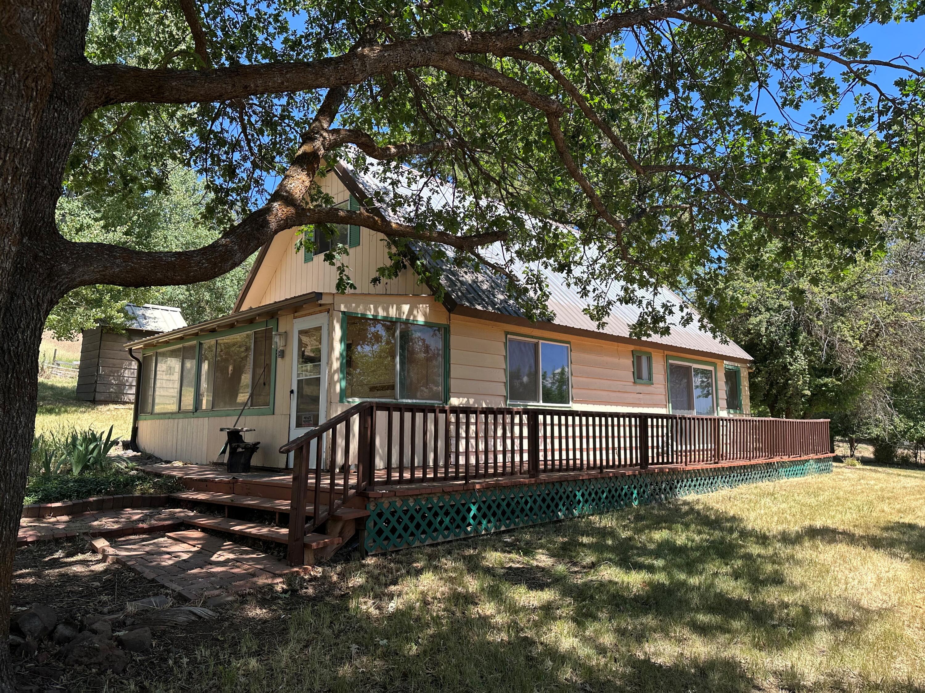 This property has potential!! 3 bedroom 1 bath home on over 2 acres in the desirable Keno area. It needs some TLC but possibilities are endless. Enter the enclosed front porch into the living space and kitchen. Bathroom and 1 bedroom on main floor with slider out to deck.  Off the kitchen is another enclosed porch/ mud room. Upstairs has 2 bedrooms with storage closet between them. Property is partially fenced with garage, two storage sheds/containers, nice trees and other flowers.  Plenty of room to park and store extra toys! Home is being sold as is. 480 Sq Ft is Finished Attic and home is 776 Sq Ft.
