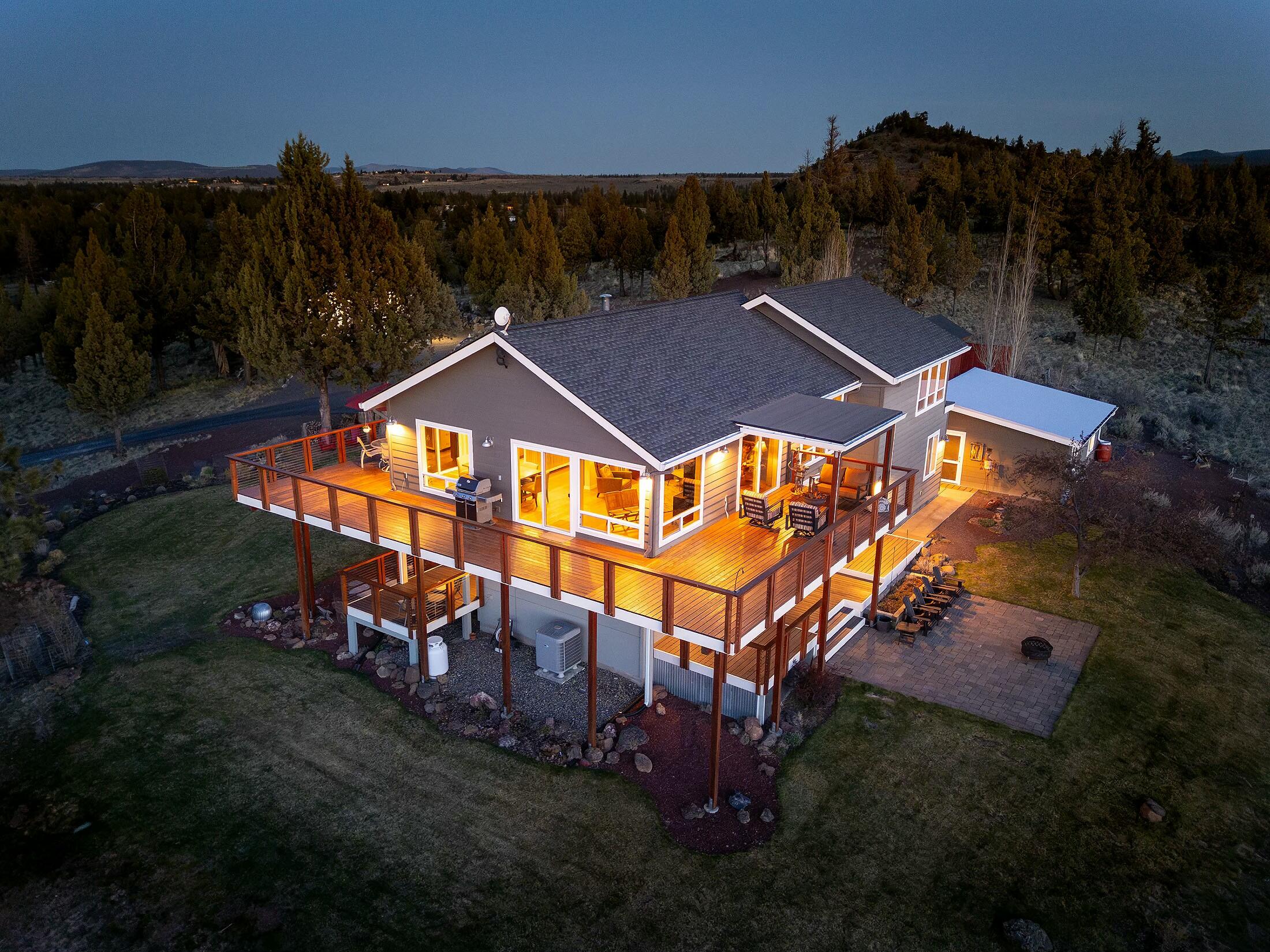 Discover unparalleled luxury and panoramic Cascade Mountain views on this breathtaking 19.7-acre Central Oregon estate. Thoughtfully crafted with unique architectural details, this elegant 3-bedroom, 2.5-bath home is designed to highlight its stunning surroundings. Vaulted ceilings and expansive windows fill the living space with natural light while framing remarkable vistas. The gourmet kitchen features high-end Jenn-Air appliances, custom cabinetry, & quartz countertops. The main floor primary suite offers a serene retreat with an updated bathroom. Expansive deck space is perfect for entertaining or savoring the views. Multiple outbuildings—including an attached 2-car garage, detached 2-car garage, and a 30' x 40' pole barn—offer ideal space for hobbies or workspace. Solar panels added in 2021 complete this private mountain-view haven.