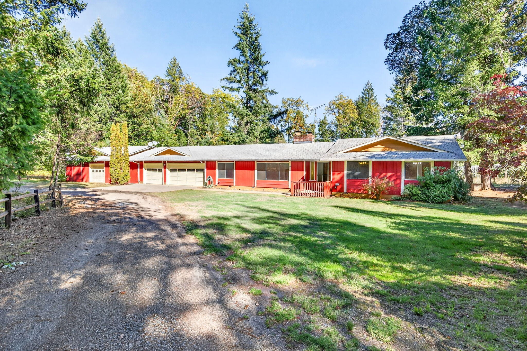 Escape to peace and privacy on 15 acres of level, park-like land surrounded by mature forest, seasonal creeks, and meandering trails. A gated entry leads to a single-level ranch-style home featuring a NEW ROOF, new LVP flooring in the living room, and inviting living spaces filled with natural light. Enjoy two wood-burning fireplaces, a spacious kitchen with tile counters, range with 5-burner cooktop, additional wall oven, microwave, and refrigerator. The primary suite opens to the backyard, and updated floors add warmth throughout. Outside, relax or entertain on the vaulted covered deck overlooking the serene backyard. Additional highlights include a 3-car finished garage, a second drive-through garage/shop, fruit trees, and plenty of room for animals, gardening, or a future barn. Strong well - tested in November at 7.75 gpm and has a 2000 gallon holding tank. Marketable timber and endless outdoor potential make this property truly special - just minutes from town, yet worlds away