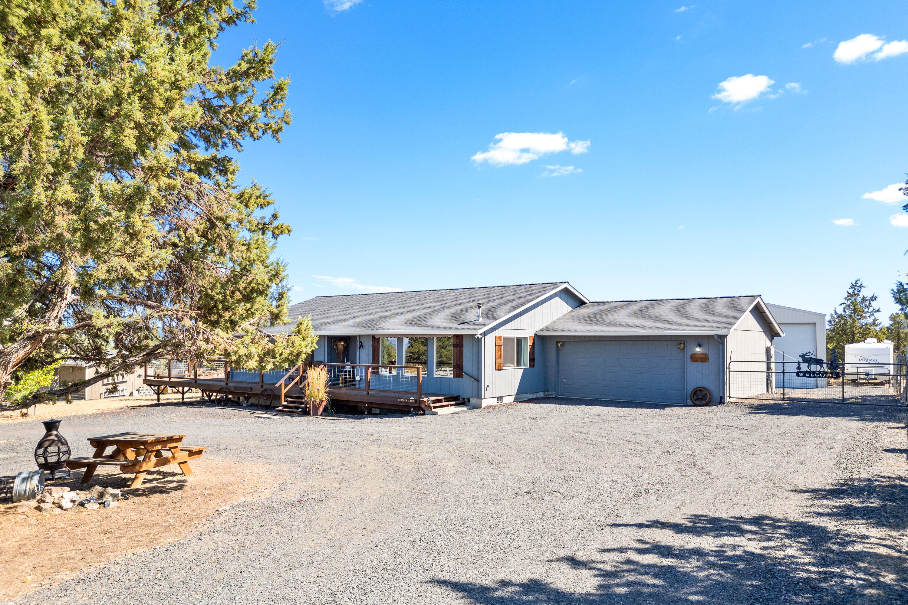 Enjoy panoramic views and peaceful living in this well-maintained and updated single-level home in Prineville, Oregon! This 3-bedroom, 2-bathroom home offers 1,704 square feet of comfortable living space, complemented by an impressive 1,500 square feet of wrap-around decking—perfect for taking in the sweeping views of the Prineville Valley and entertaining year-round. Inside, you'll find an open floor plan with a light-filled living room, cozy pellet stove, a family room, and an open kitchen and dining area. The property also features a massive 1,651 SF shop with 14' door and 16' eaves—ideal for
RVs, hobbies, or storage. Set on 2.14 fenced acres, there's plenty of room for your toys and animals. Updates include new roof, windows, mini splits and more. HOA includes water and snow removal for added convenience. This is Central Oregon living at its best—don't miss your chance to see it!