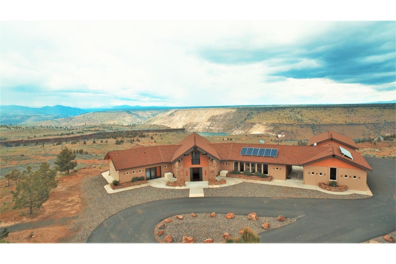 Property located in 3 Rivers Rec, a gated community, off-the-grid, with private access to Lake Billy Chinook. Every so often, art is created w/brick & mortar & this is a masterpiece. Sophisticated & unique are just few of the words to describe this incomparable custom home inside & out. From the elegant design, to the exquisite details, to the use of stone, granite, handmade tiles & wood in every corner of the property makes this extraordinary character timeless. 5 acres w/Lake and Cascade views from every room, 3BR, 3.5 BA, 2 detached garages---1 for vehicles & 1 for Toys. Well, state-of-the-art solar system & much more.
