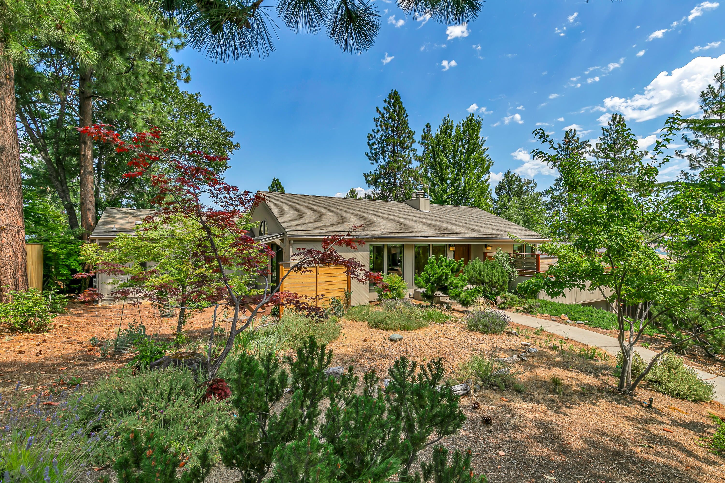 Tastefully renovated midcentury view home with new detached studio office, located near hiking and trail-riding just above Southern Oregon University! Great room with vaulted ceiling, exposed beams, gas fireplace with stone hearth, media area with built-ins and surround-sound, gourmet kitchen with stainless Thermador appliances including 6-burner gas cooktop, stone counters, butcher block island, skylights, and dining area with wood fireplace. Solid oak hardwood floors throughout main level - including primary with full ensuite bath, limestone vanity and shower surround, and walk-in closet. Two lower-level bedrooms with closets and new carpet, full bath with dual vanity, laundry mudroom or potential guest kitchenette, two storage rooms, and two-car garage. French doors from great room or primary to view deck, fully-fenced backyard with poured concrete and stone patios, and studio with metal-clad exterior, wood-paneled interior, and floor-to-ceiling windows. Inquire for details!